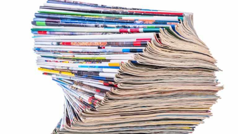 Pile of old paper colored magazines isolated on white background