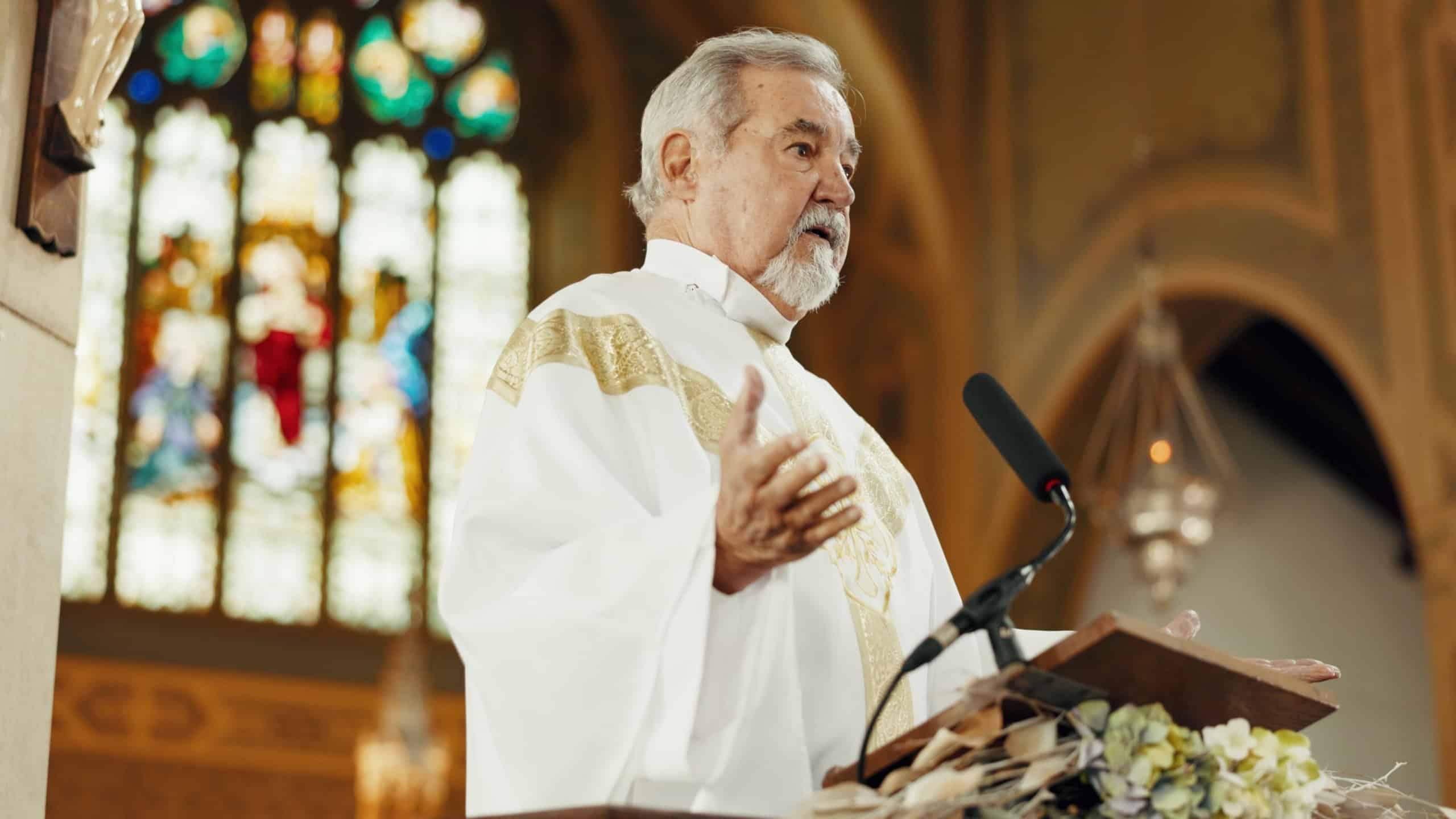 Religion, priest and man preaching in church for sermon, heaven and gospel of God. Senior pastor, spiritual leadership and speech for worship, holy spirit and community prayer service of Jesus Christ