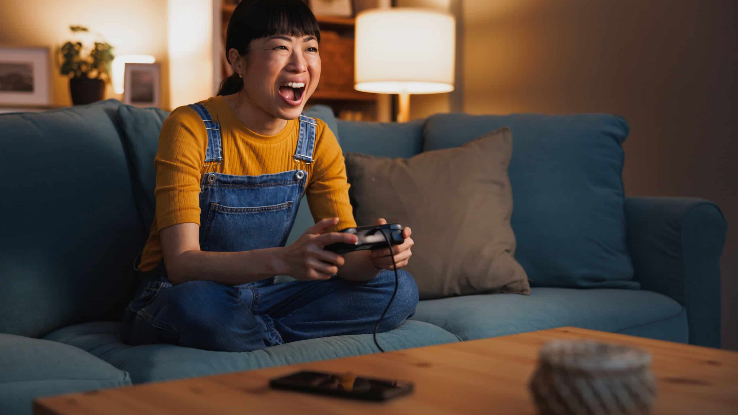 Beautiful woman having fun at home late at night playing video games enjoying her leisure time and relaxing