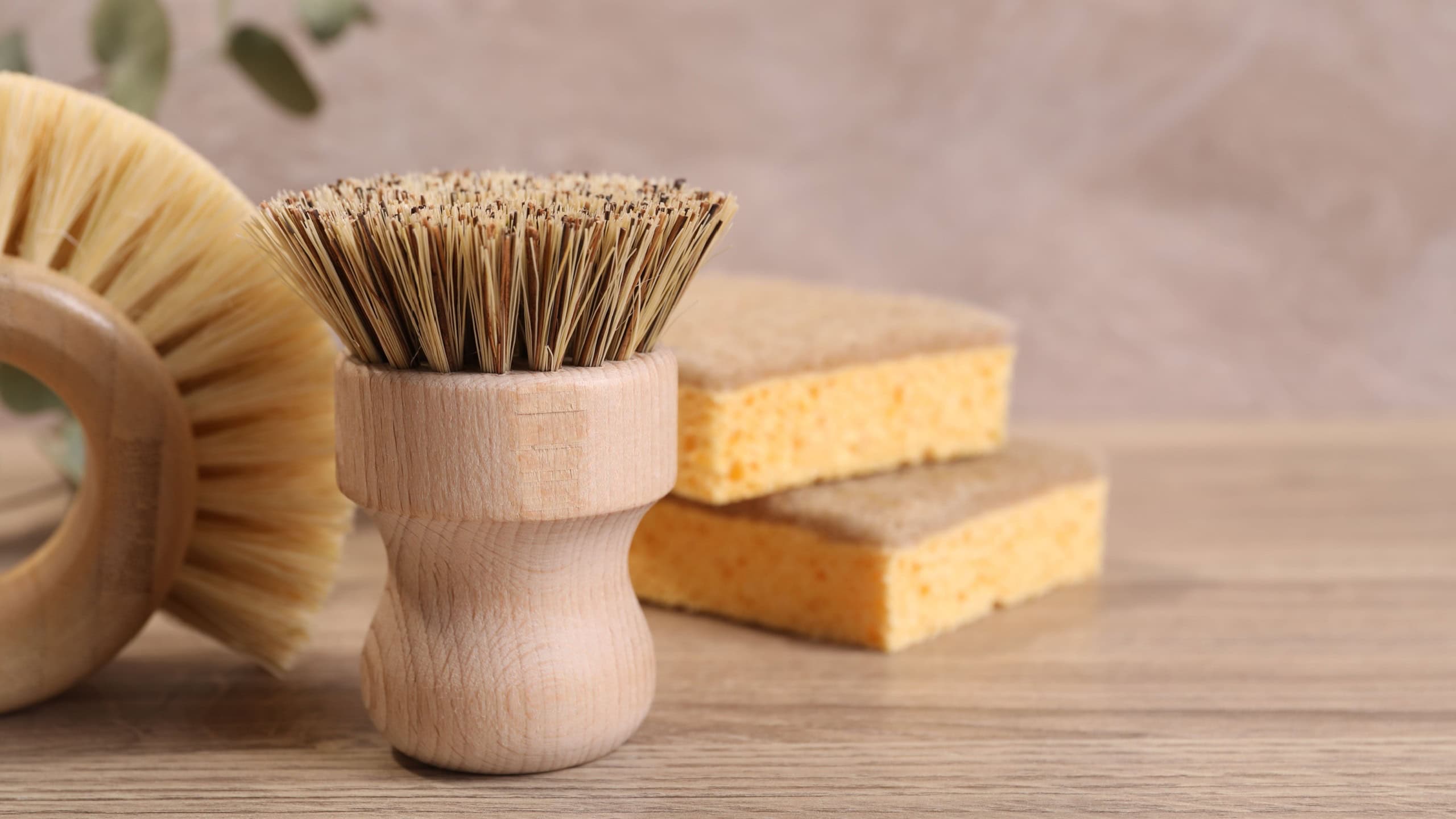 Small cleaning brush on wooden table, closeup. Space for text