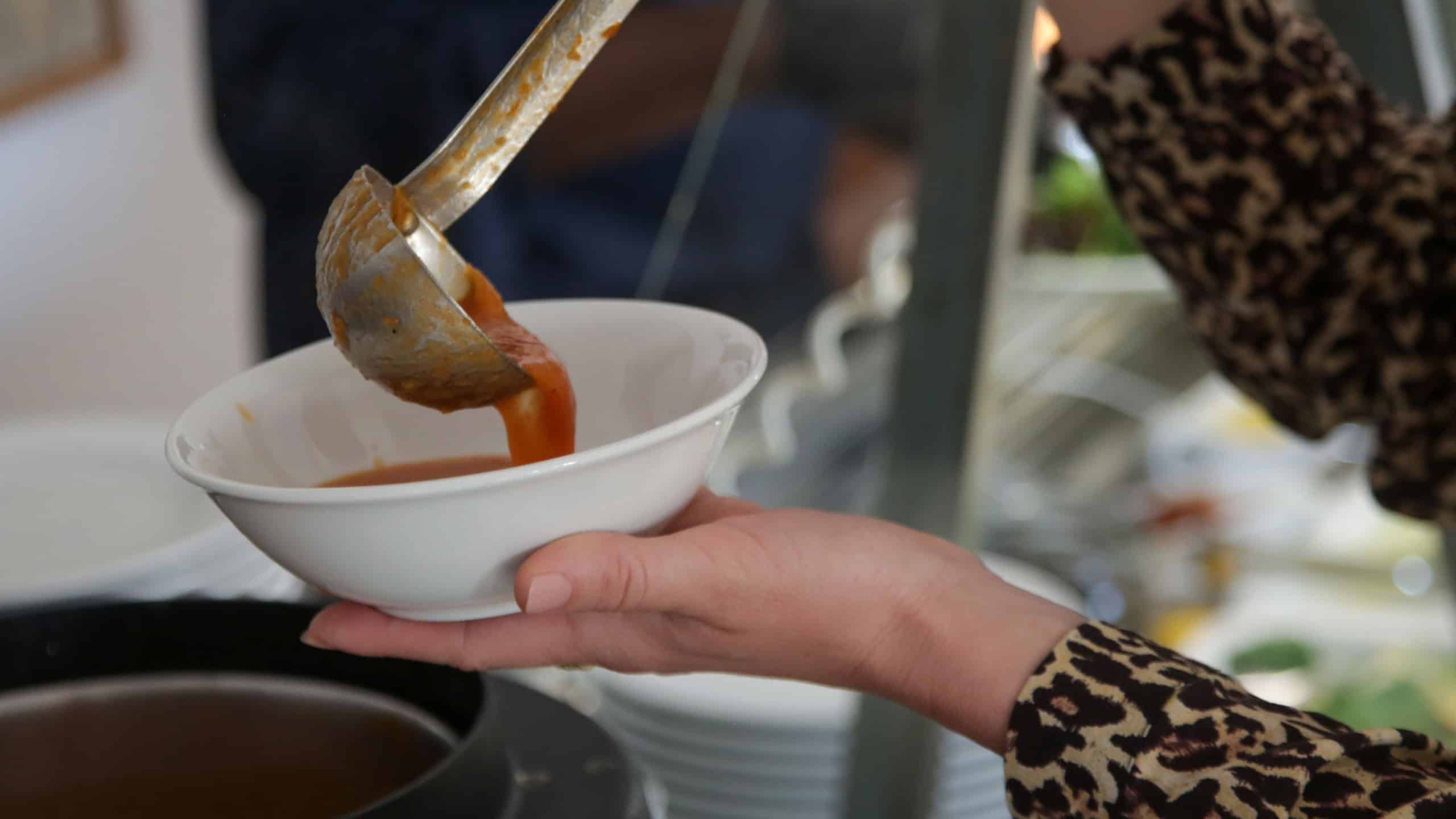 Woman taking soup from a buffet line