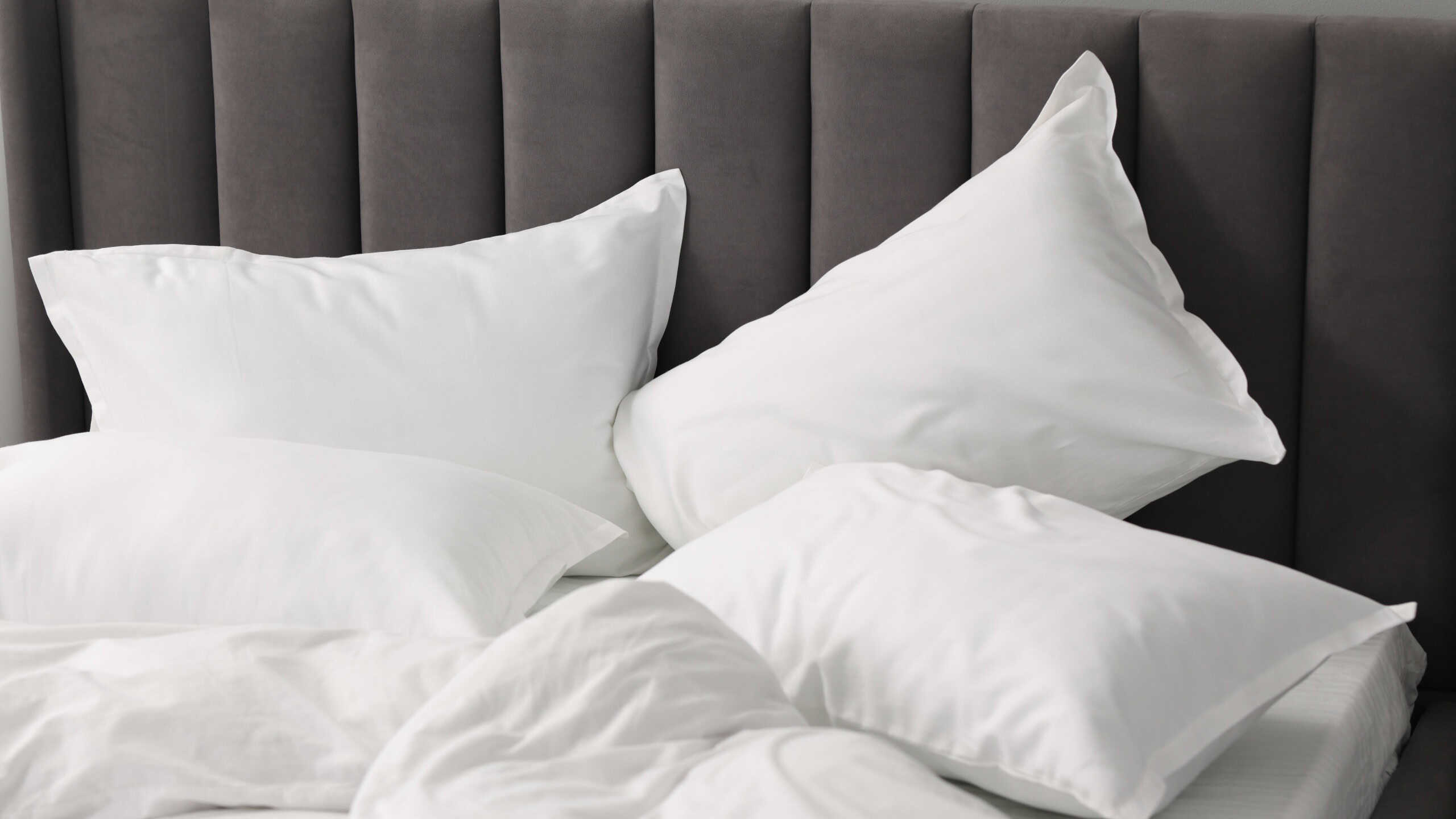 Many soft pillows on bed at home