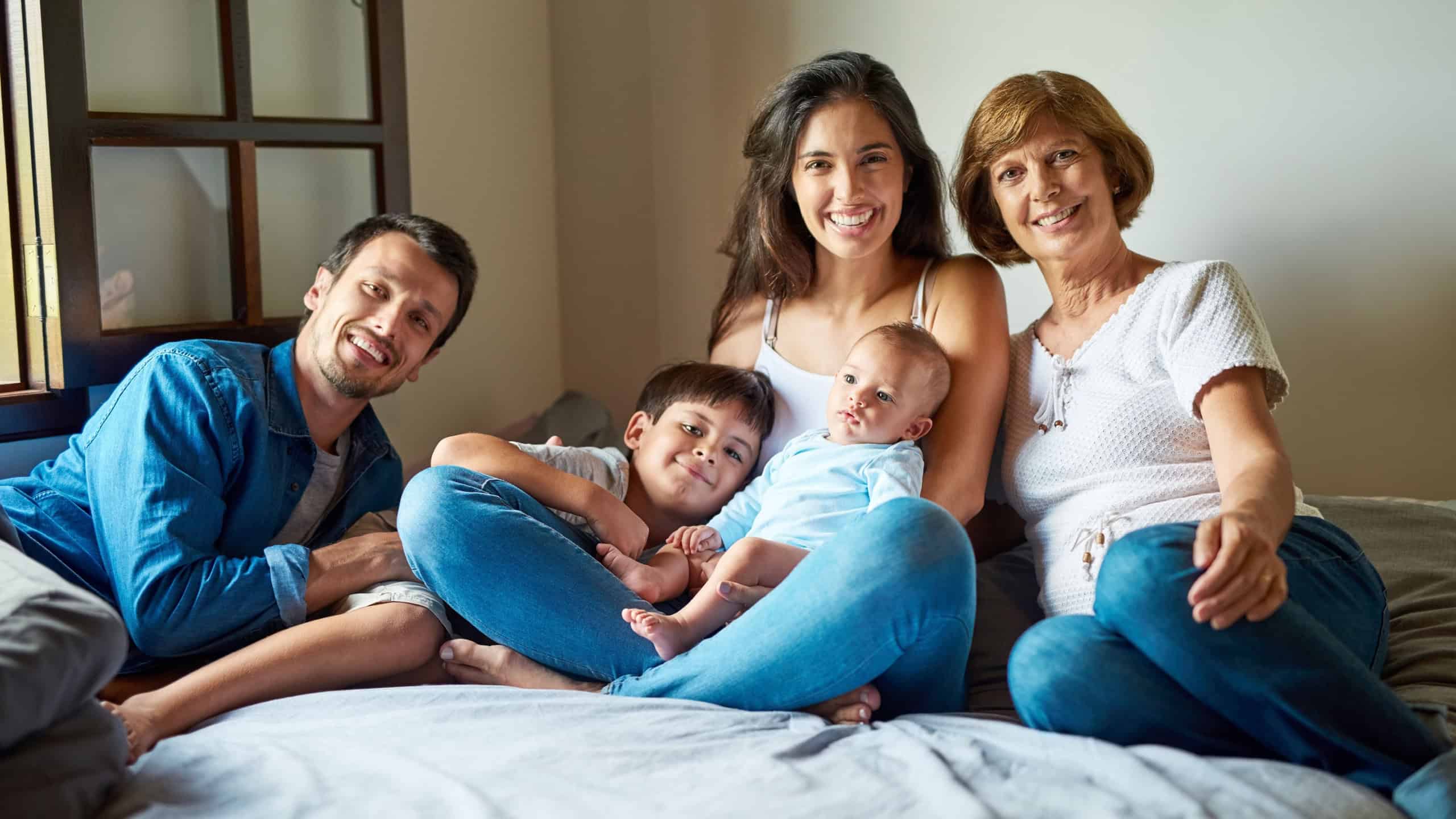 Big family, portrait and bonding in home with grandmother, parents and baby together. Love, smile and father relax with mother and happy child in house bedroom with generation support and care