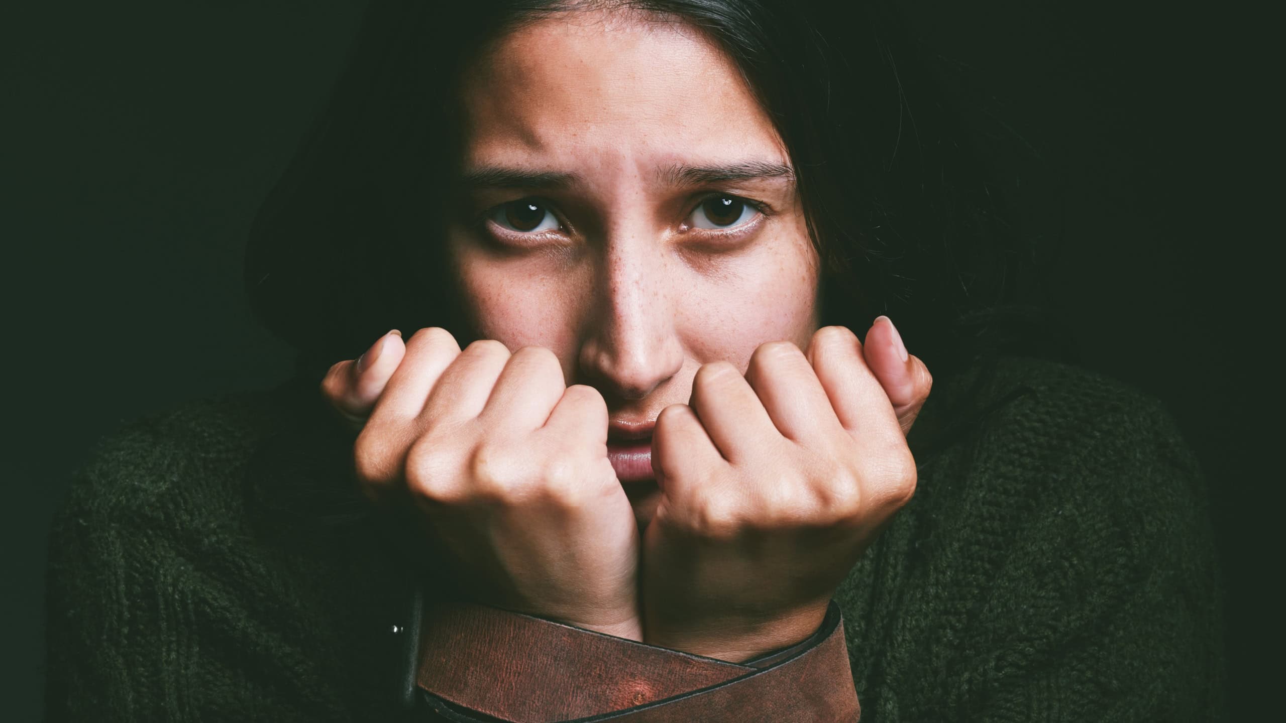 Kidnap, woman and victim with hostage portrait in studio with fear, scared and domestic violence danger. Belt bondage, sad girl or vulnerable person with trauma, abuse or helpless on black background