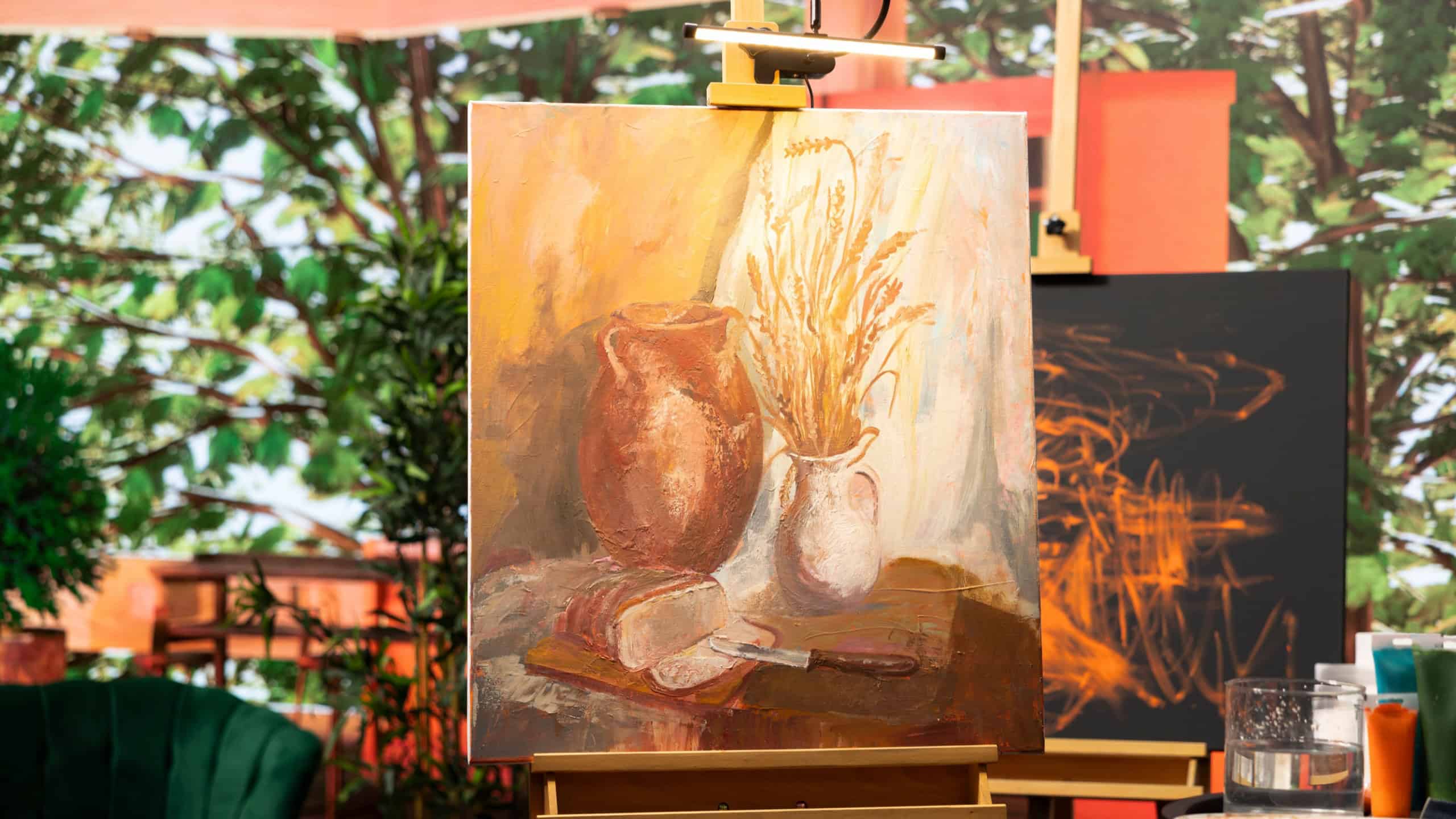 Empty artistic atelier with a rustic watercolor painting displayed on canvas, creative process with acrylic paint in a contemporary art and craft workshop. Masterpiece creation and supplies.