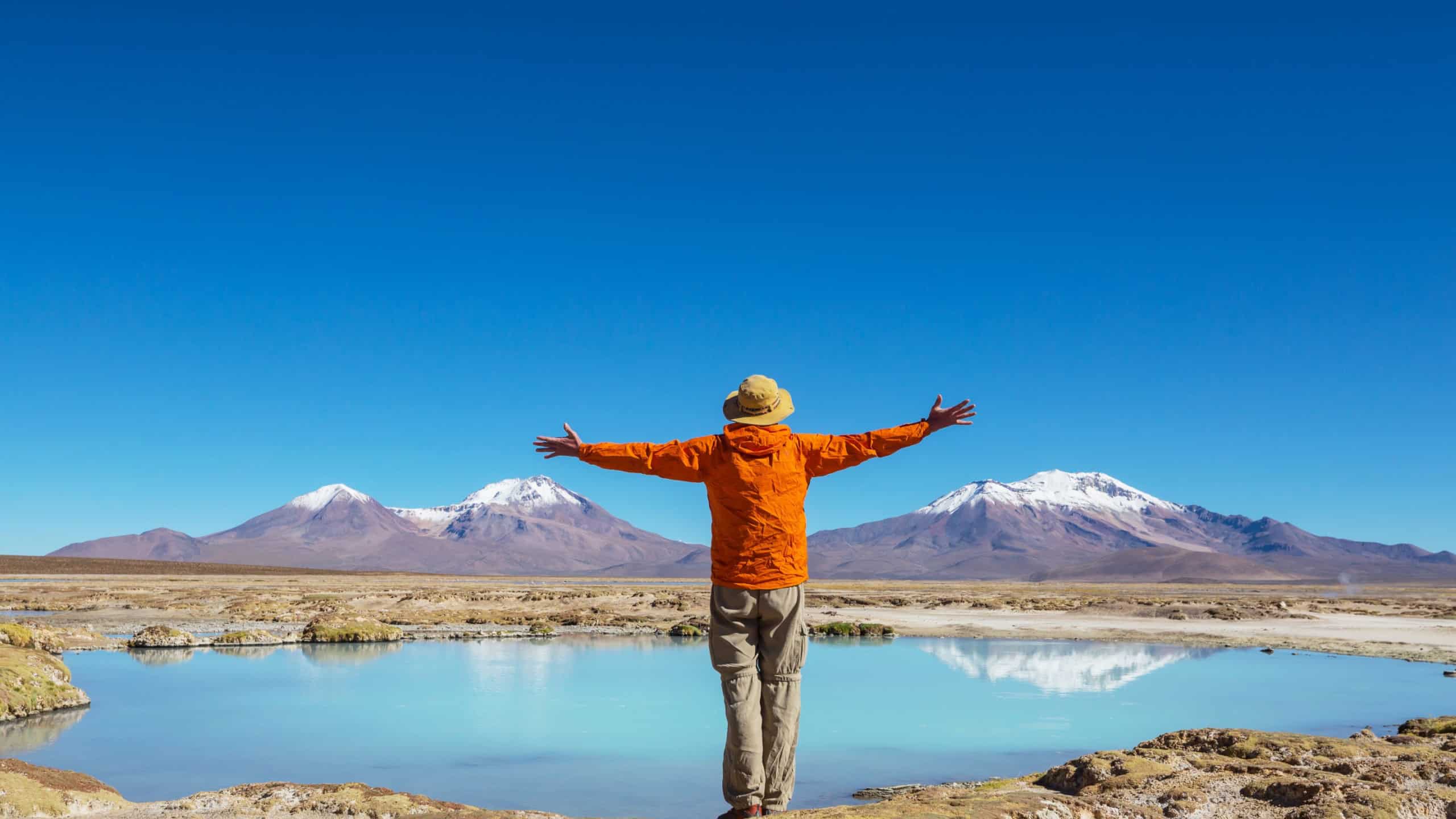 Tourist near beautiful blue lagoon on Altiplano, Northern Chile, South America