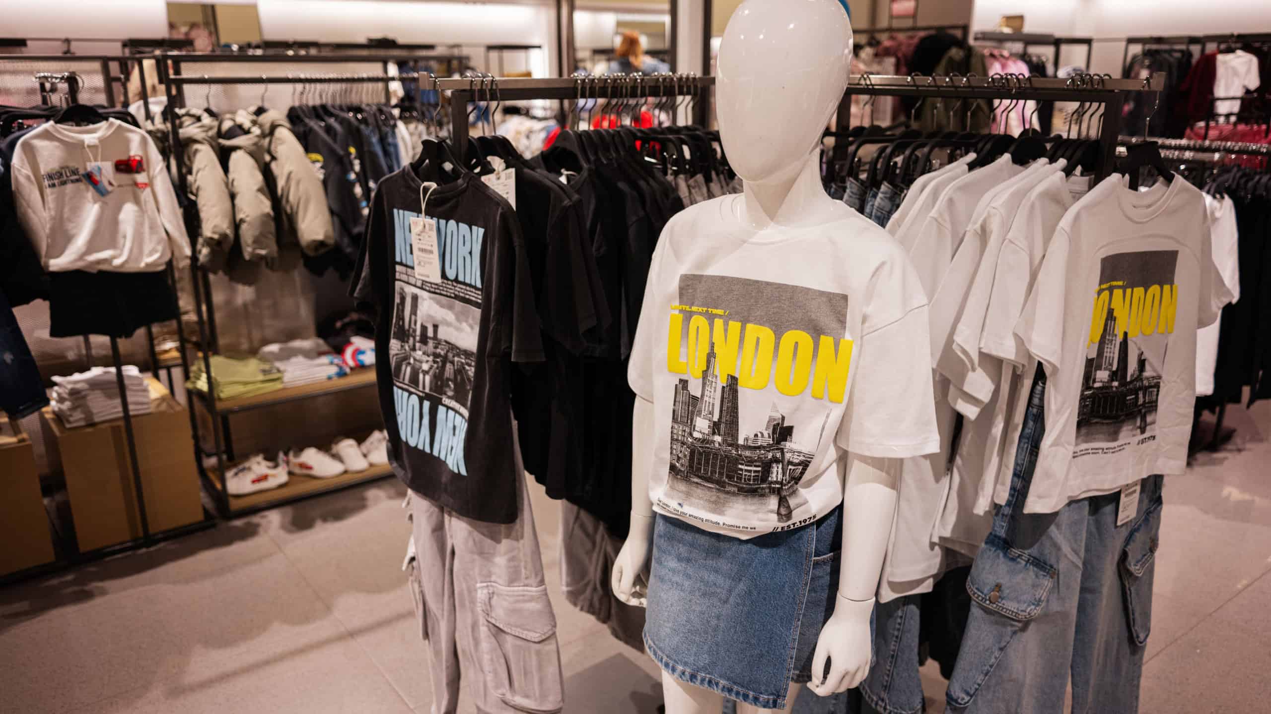 Lviv, Ukraine - March 13, 2025: Fashion retail showcasing trendy city-themed shirts paired with different casual styles on mannequins