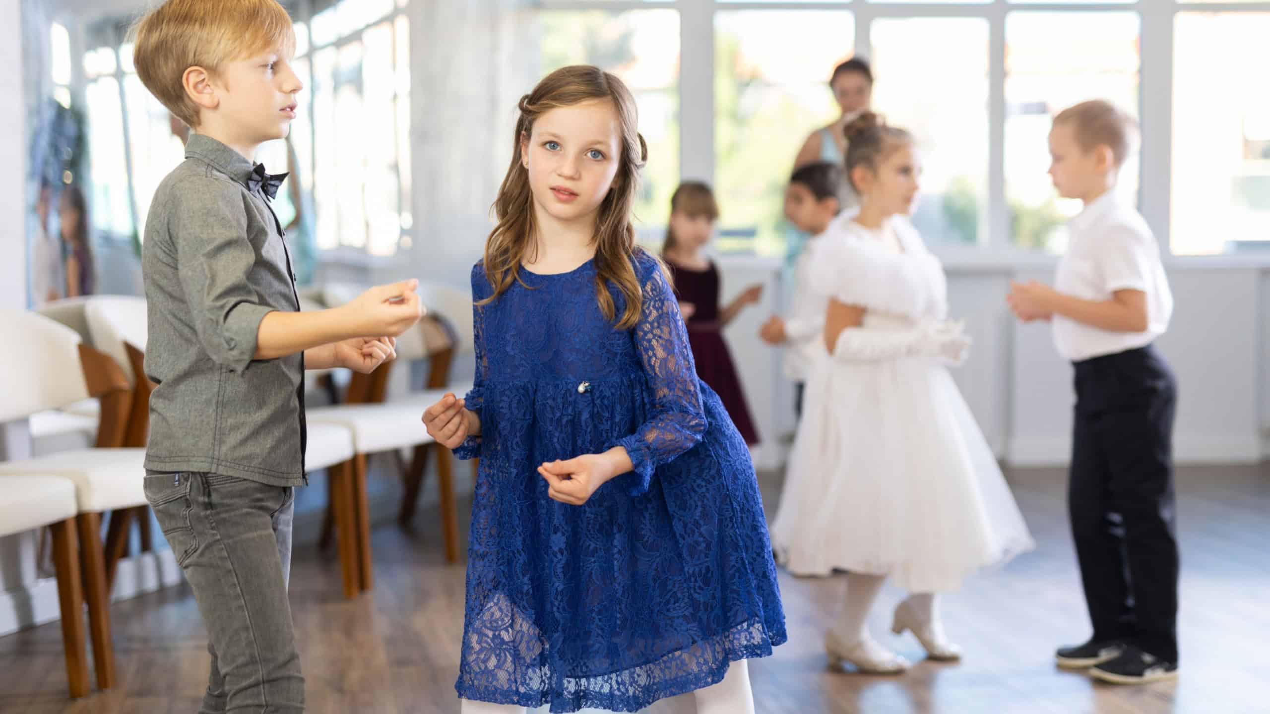 Beautifully dressed little boys and girls dance a couple twist dance