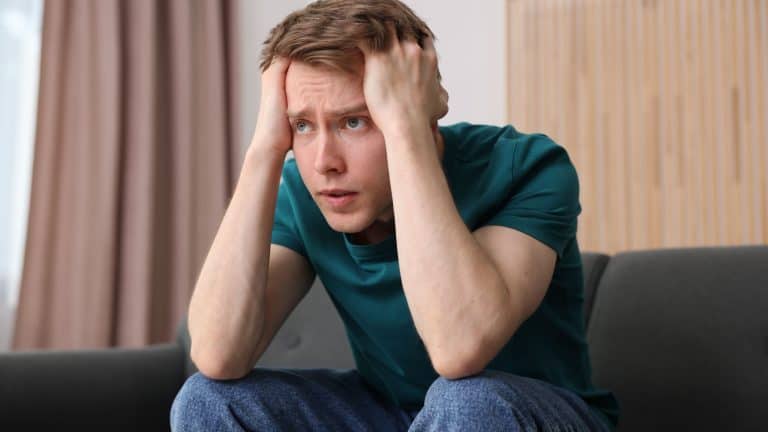 Man suffering from paranoia on sofa at home
