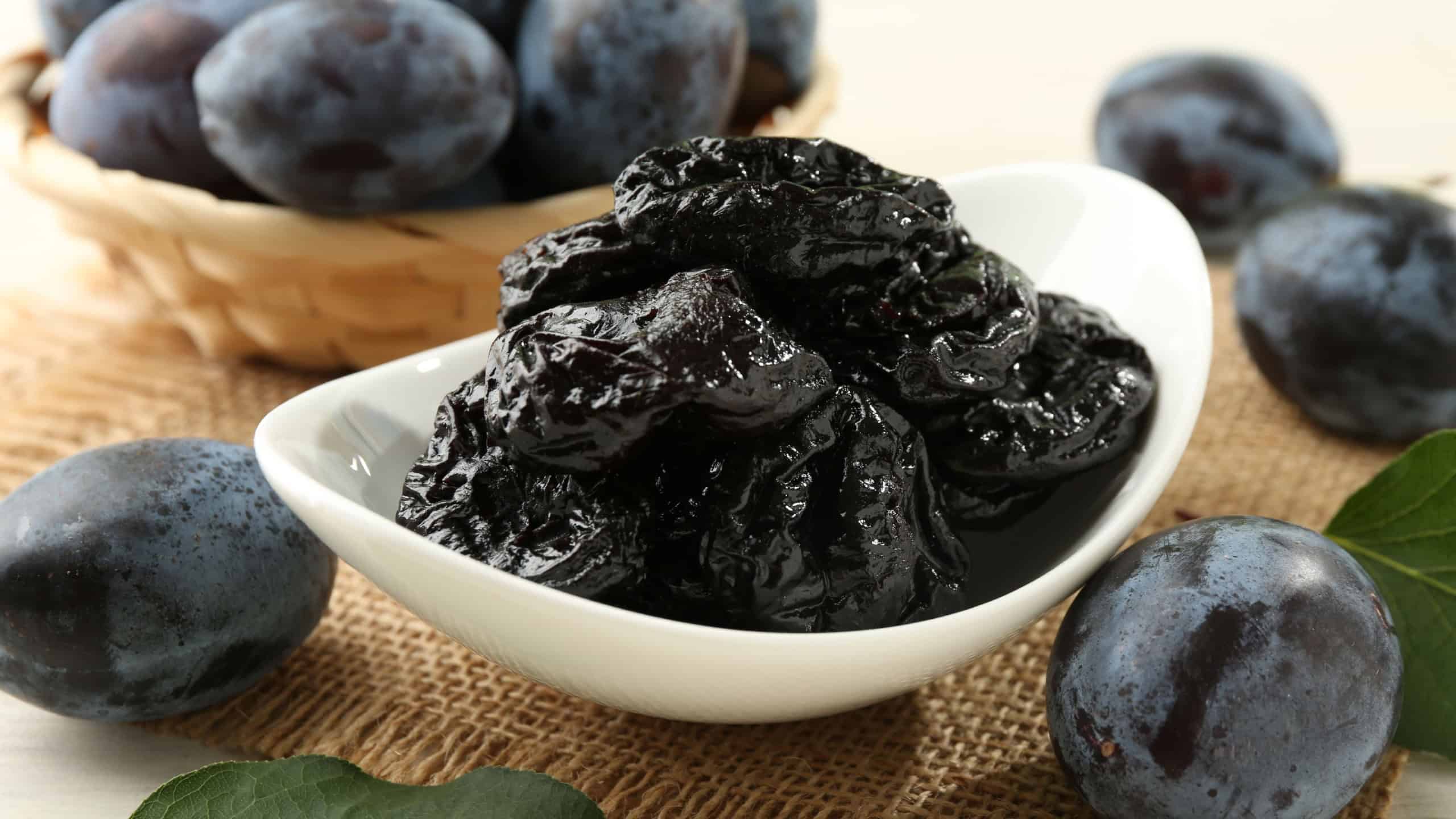 Dried prunes and fresh plums on table, closeup