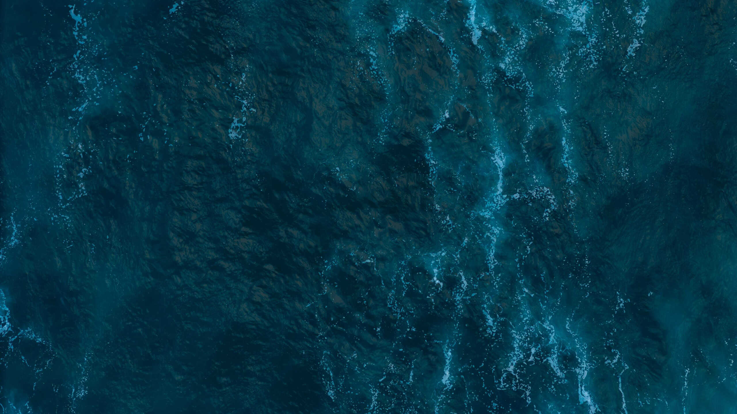 Aerial top down view of Atlantic oceanic waves rolling and creating foam patterns, Drone filming breaking surf with foam in Atlantic ocean