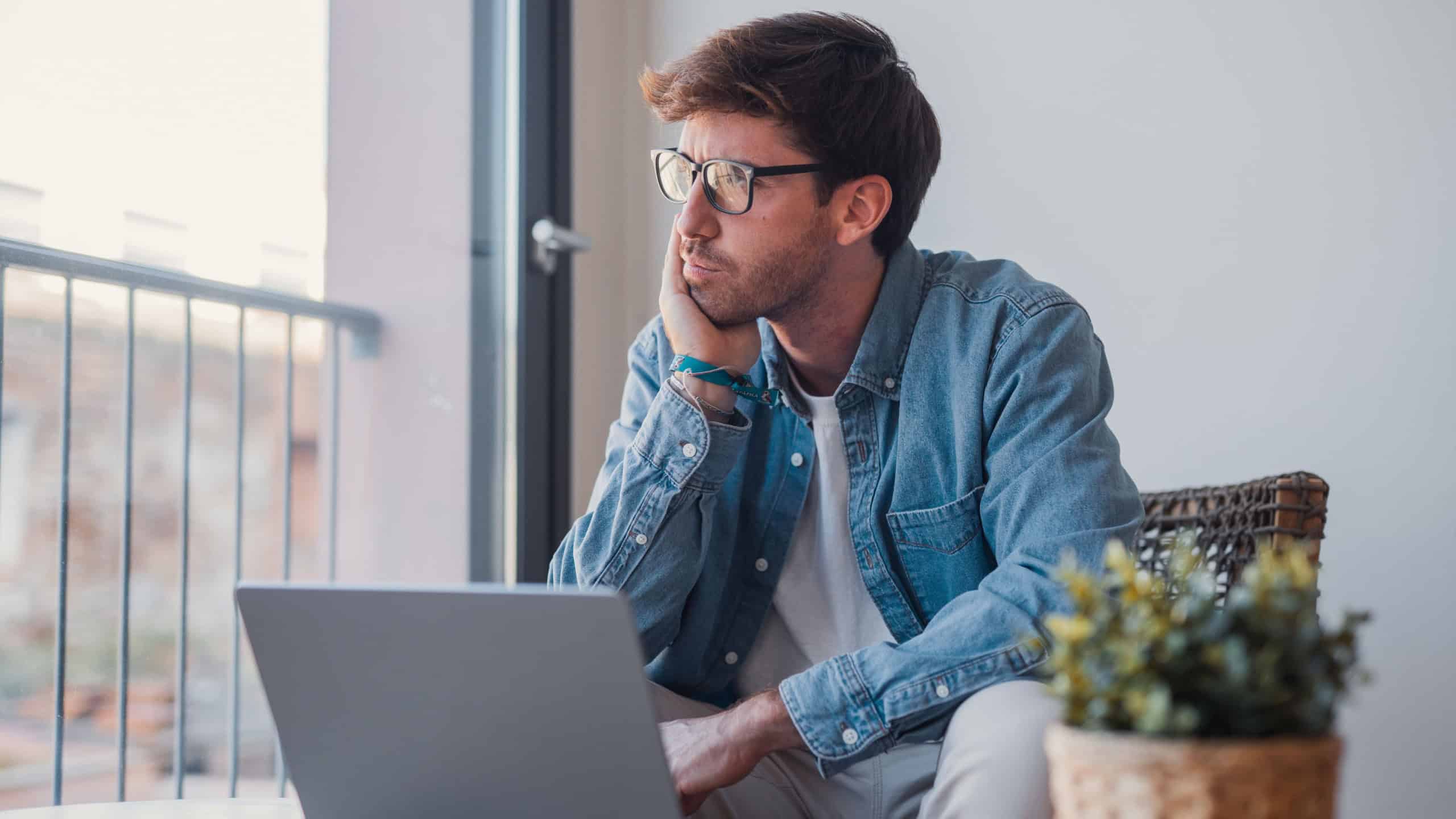 A young businessman works on his laptop in the office, analyzing finance reports and company budgets while researching investment proposals and developing strategic ideas for business growth