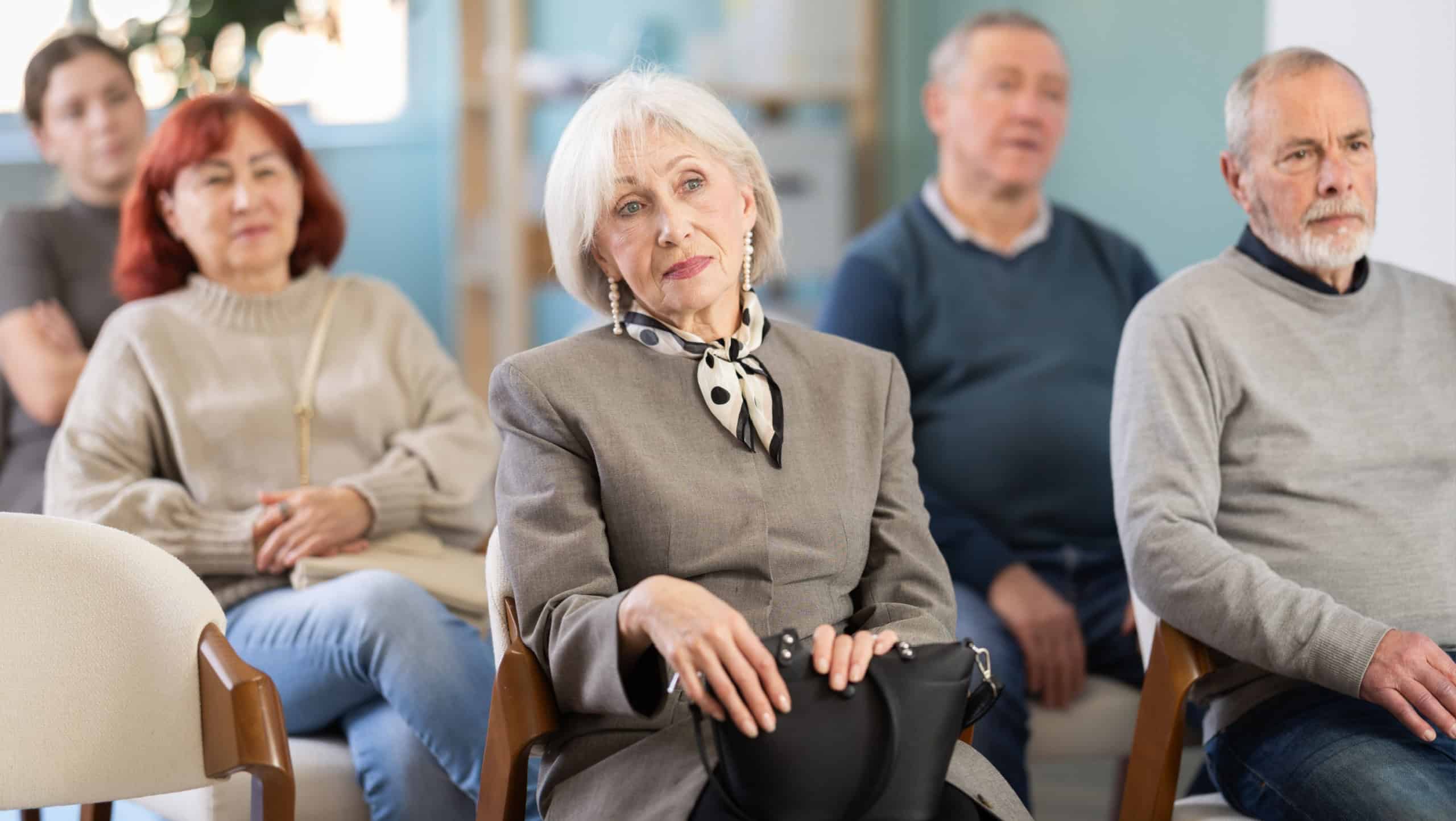 Interested senior woman listening and watching presentation during an interactive social session