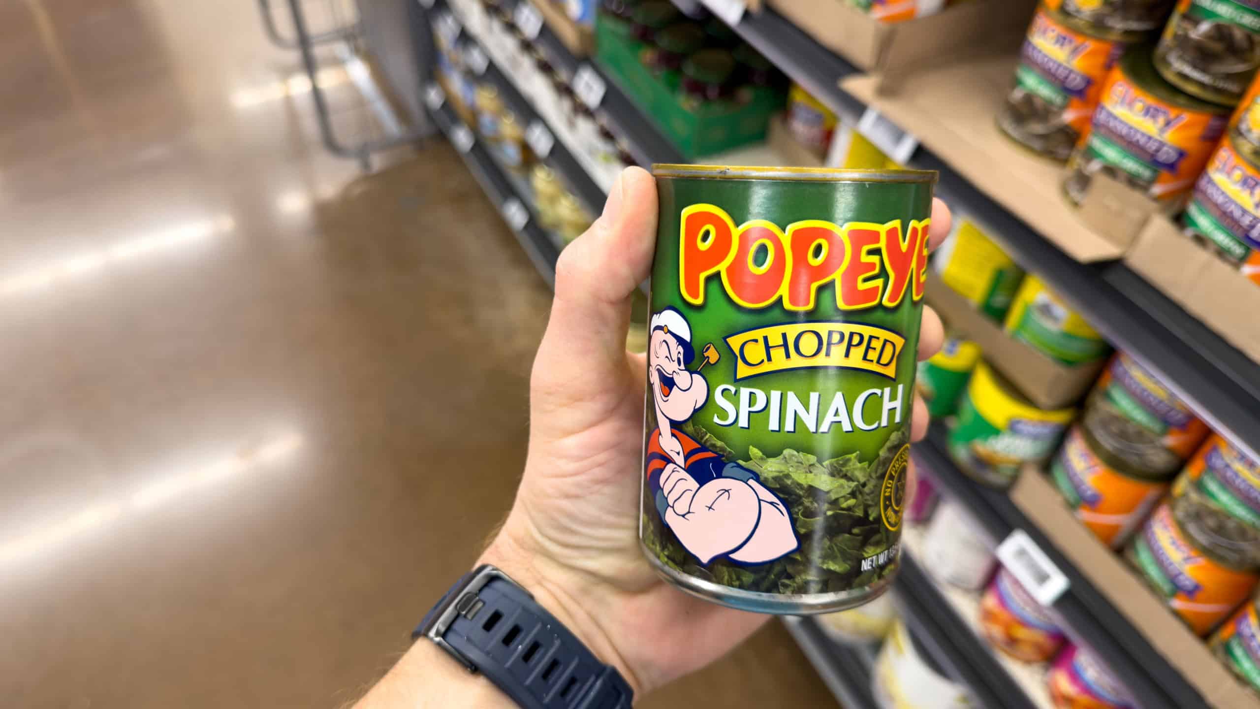 Los Angeles, CA - Marc 5, 2026: Popeye Chopped Spinach Can Held In Grocery Store Vegetable Aisle