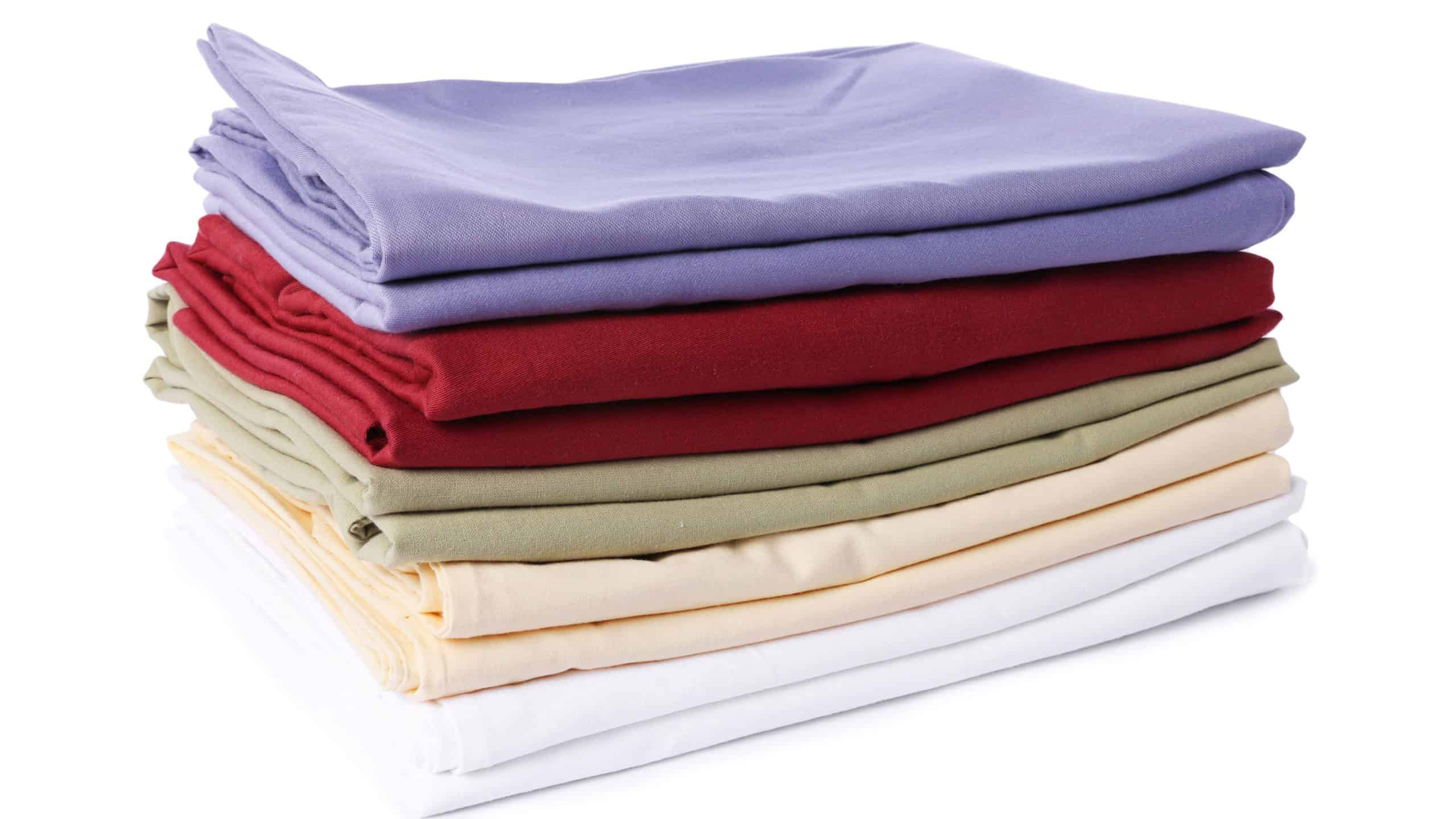 Stack of fresh bed linens isolated on white