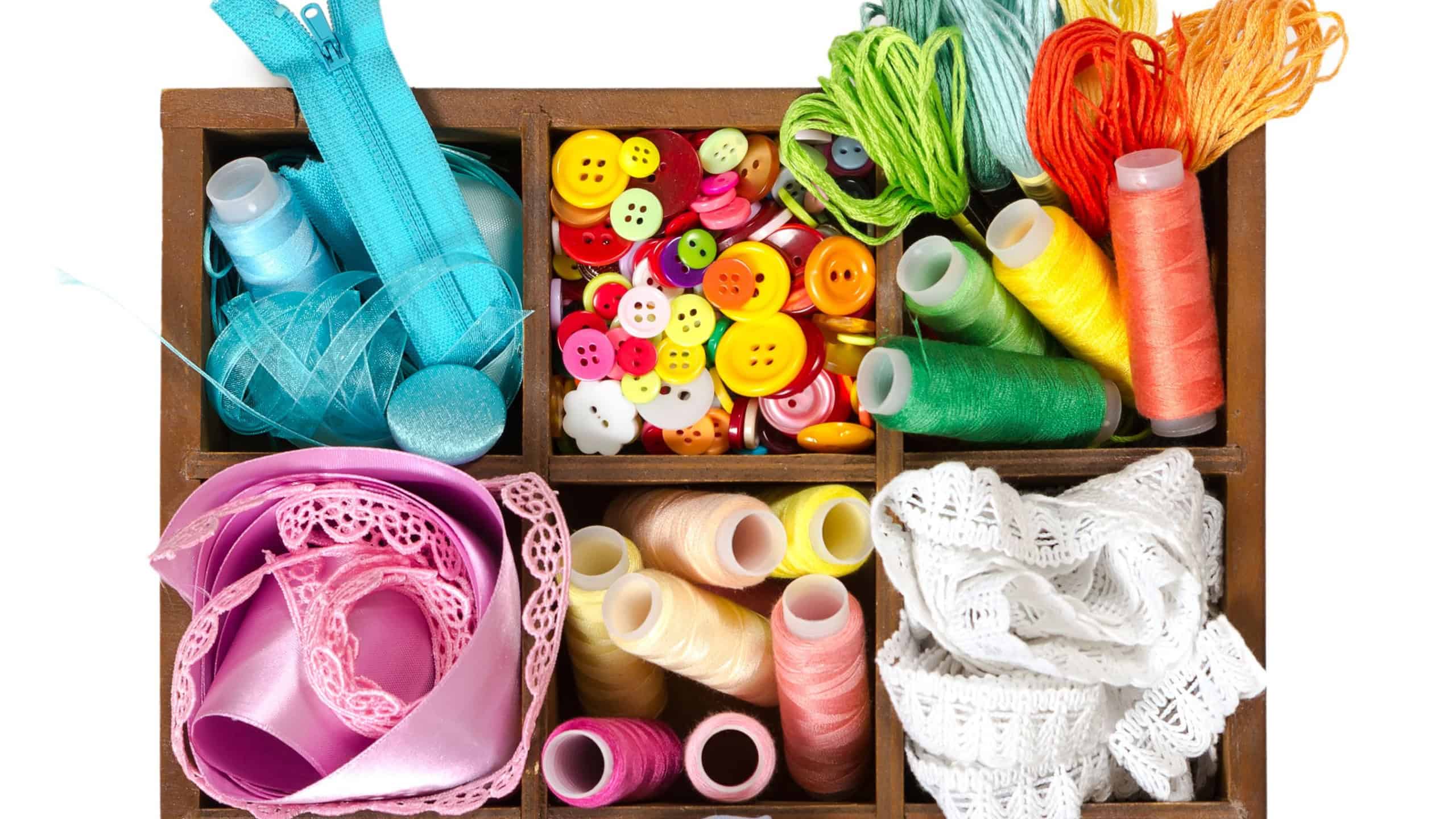 Wooden box with sewing accessories isolated on white background. Top view.
