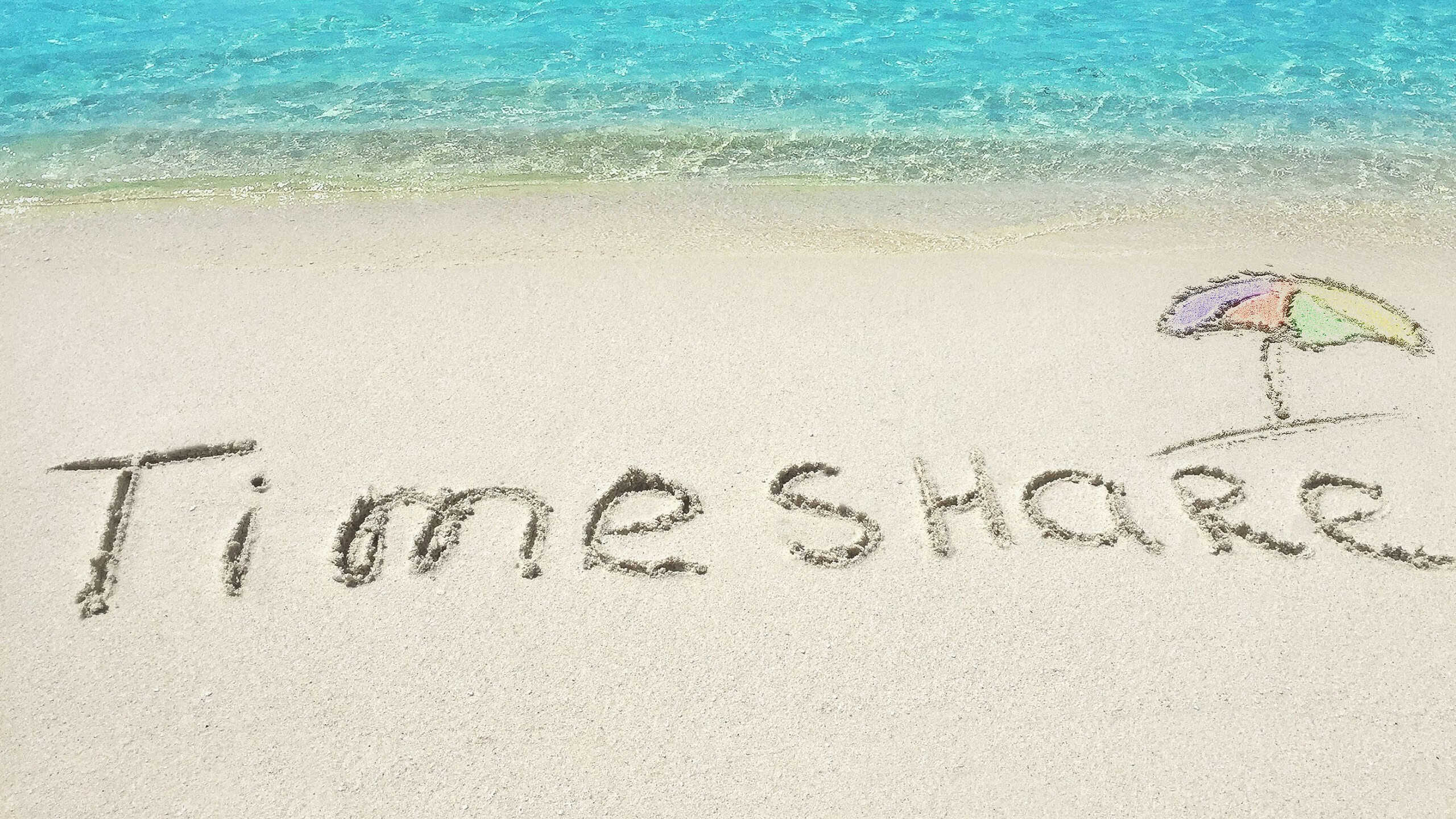 Inscription "Timeshare" in the sand on a tropical island