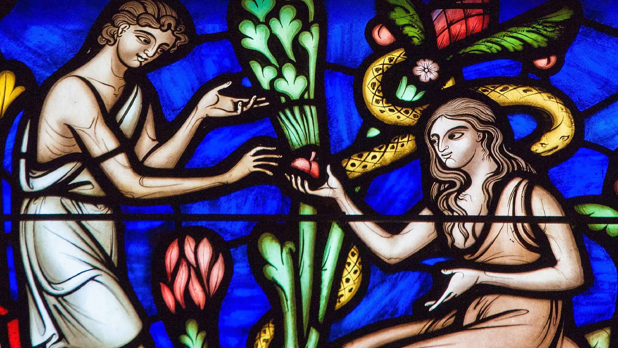 BRUSSELS, BELGIUM - JULY 26, 2012: Adam and Eve eating the Forbidden Fruit in the Garden of Eden on a stained glass window in the cathedral of Brussels.