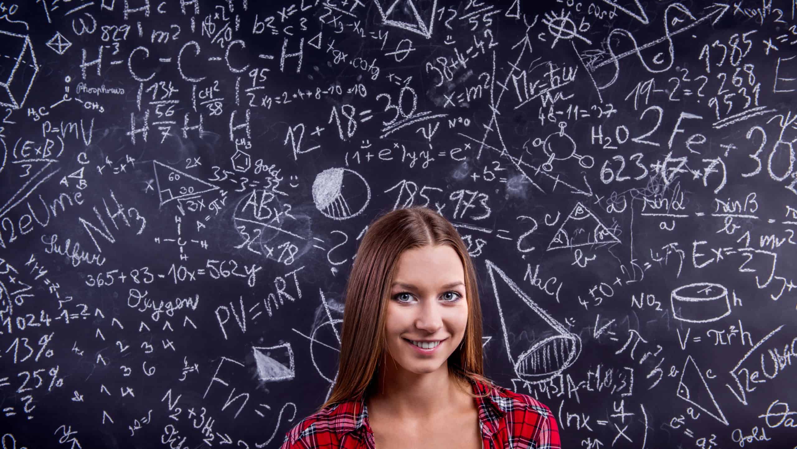 Student against a big blackboard with mathematical symbols
