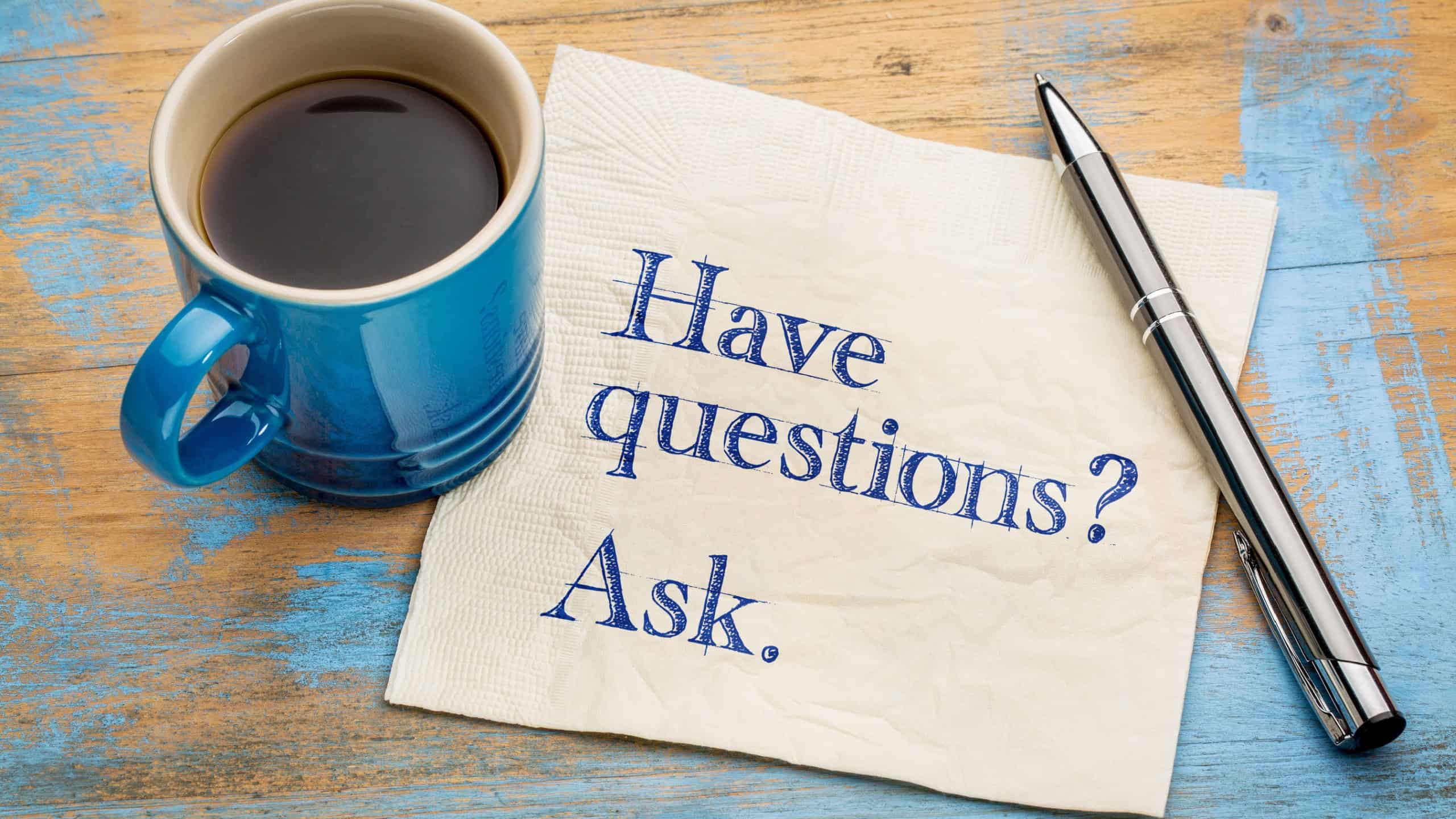 Have questions? Ask. Handwriting on a napkin with a cup of espresso coffee