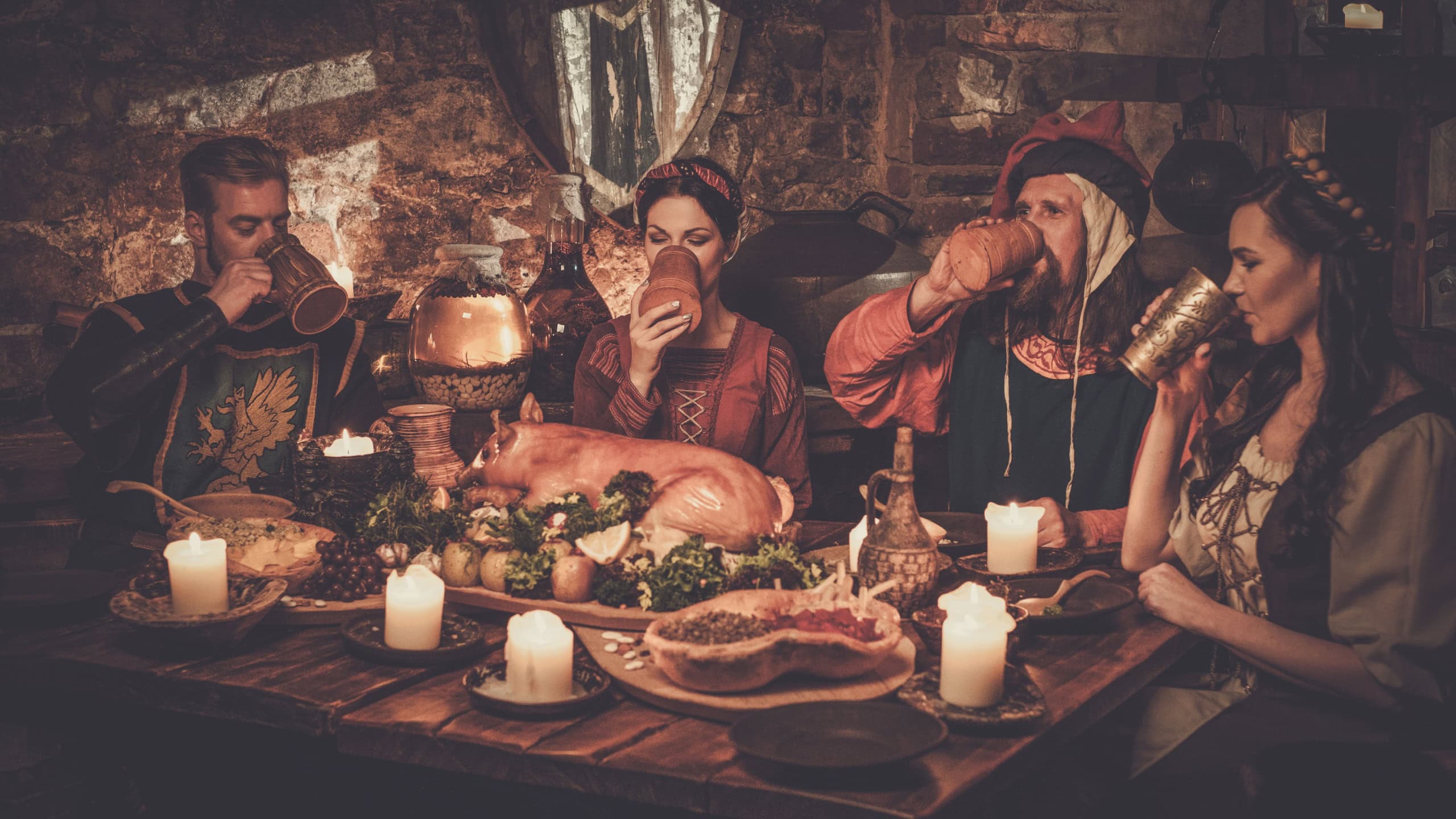 Medieval people eat and drink in ancient castle tavern.