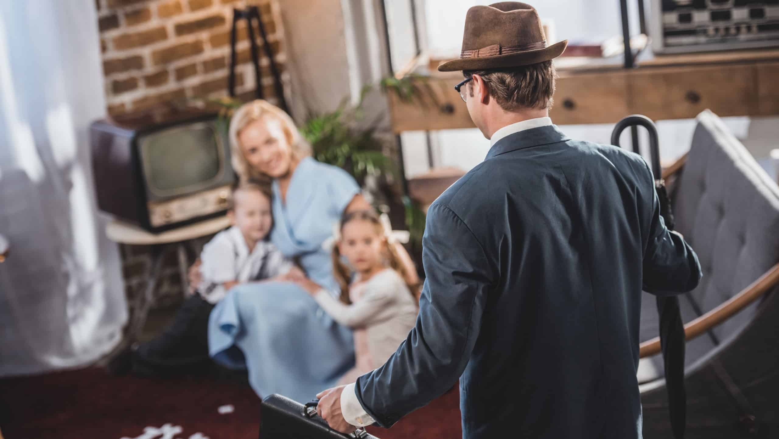 selective focus of mother with two kids playing together and looking at father coming home, 1950s style