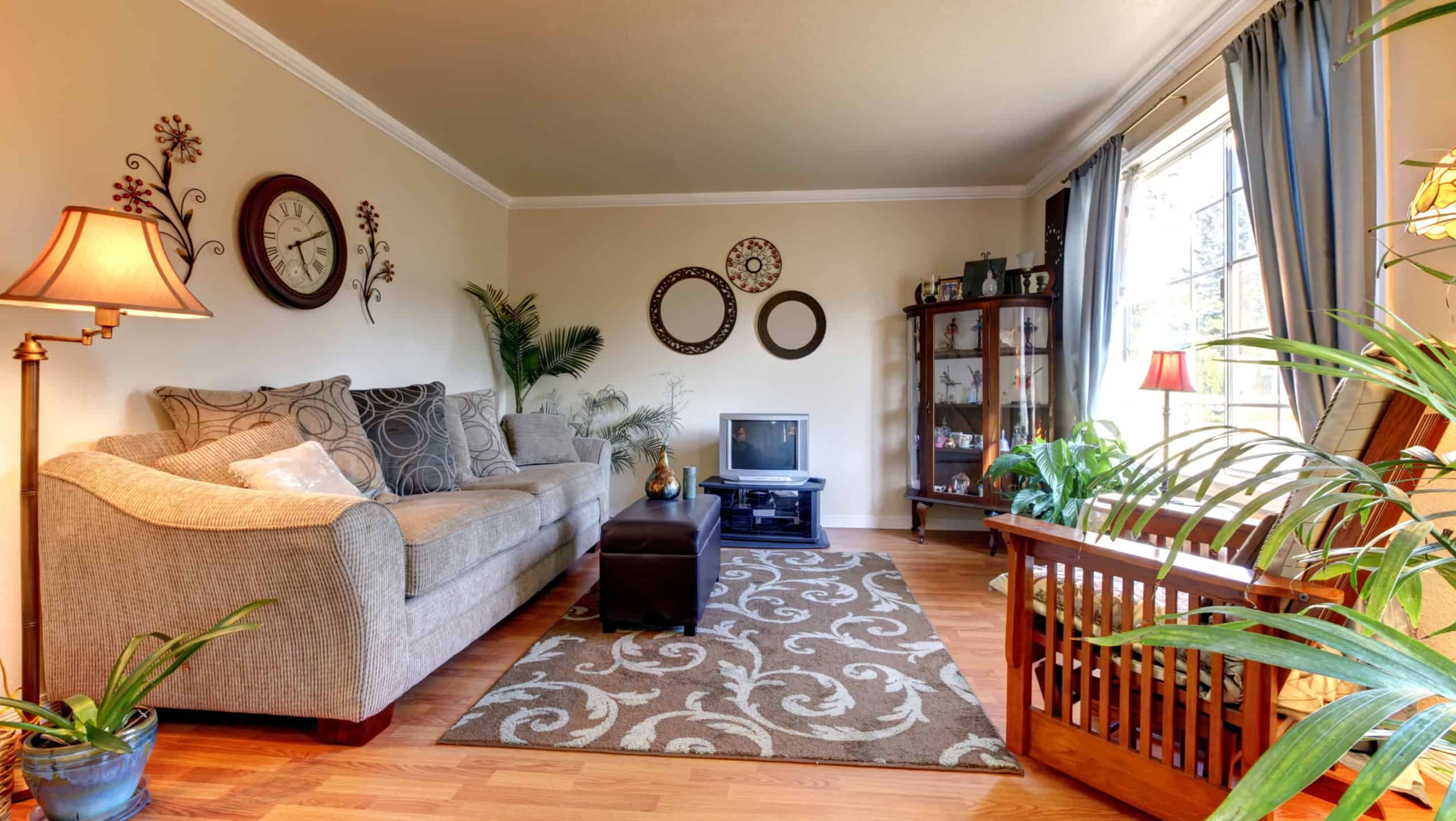 Elegant beige living room with blue and old mall TV and hardwood floor.