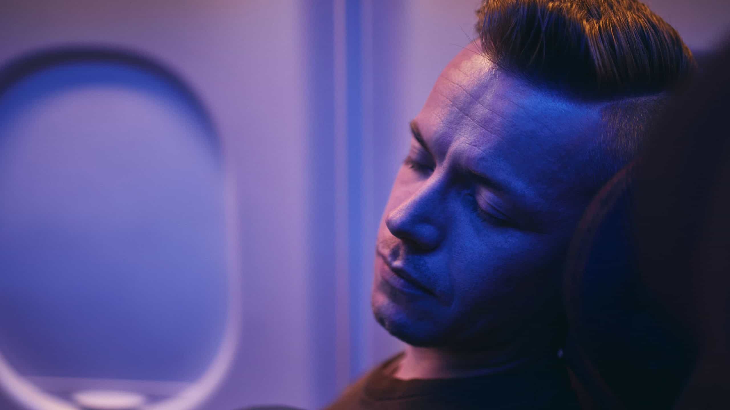Travel by airplane. Man sleeping during night flight.