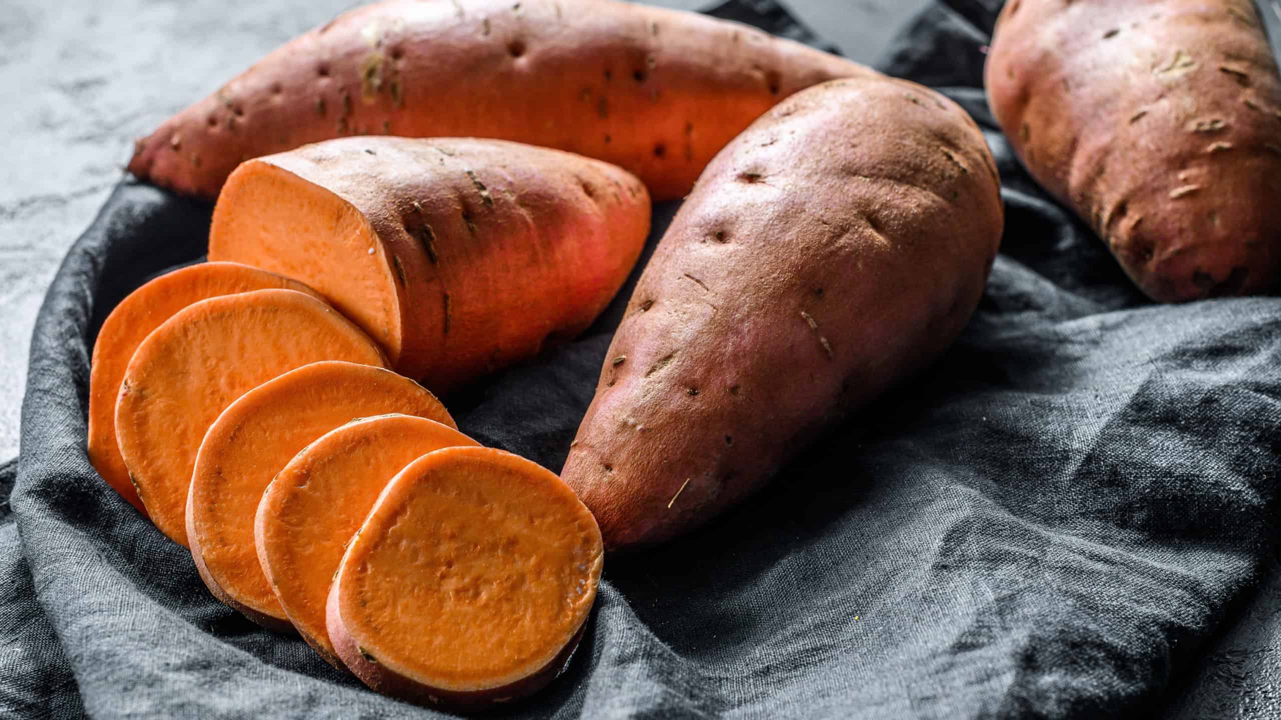 Raw sweet potatoes, organic yam. The farm food. Black background.