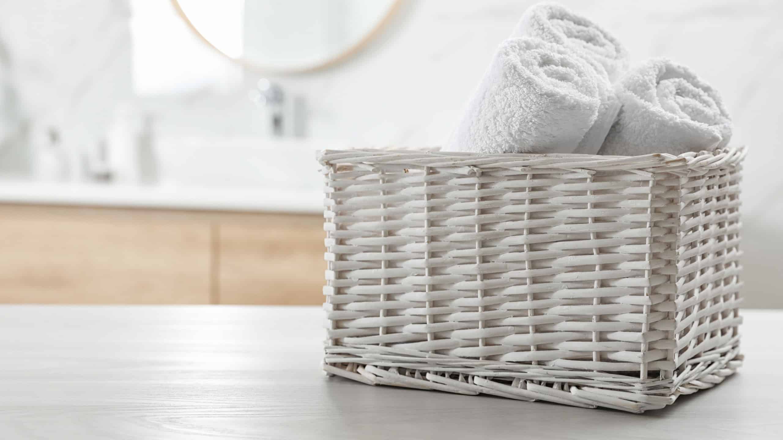 Rolled fresh towels on white table in bathroom