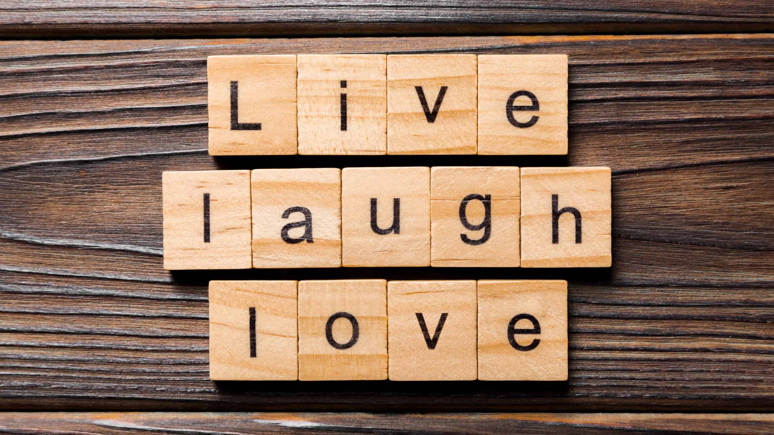 Live laugh love word written on wood block. Live laugh love text on wooden table for your desing, concept.