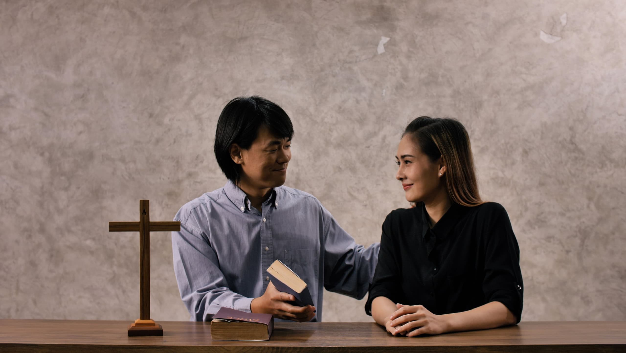 Young missionary is giving Bible advice to young woman in church.