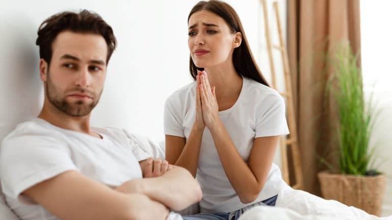Unhappy Wife Pleading Offended Indifferent Husband For Forgiveness After Infidelity In Bedroom At Home. Woman Begging Man Not To Breakup. Marriage And Relationship Problems.