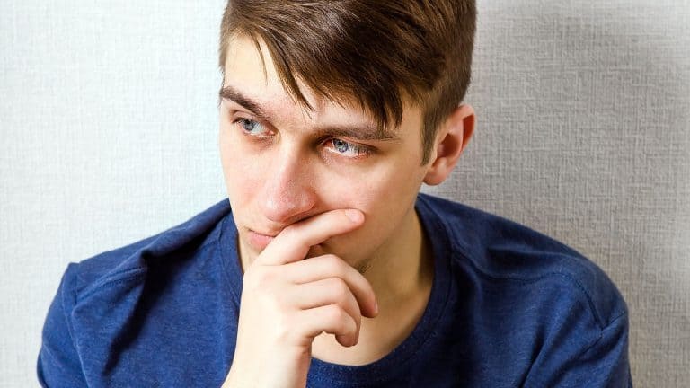 Sad Young Man by the Wall in the Room