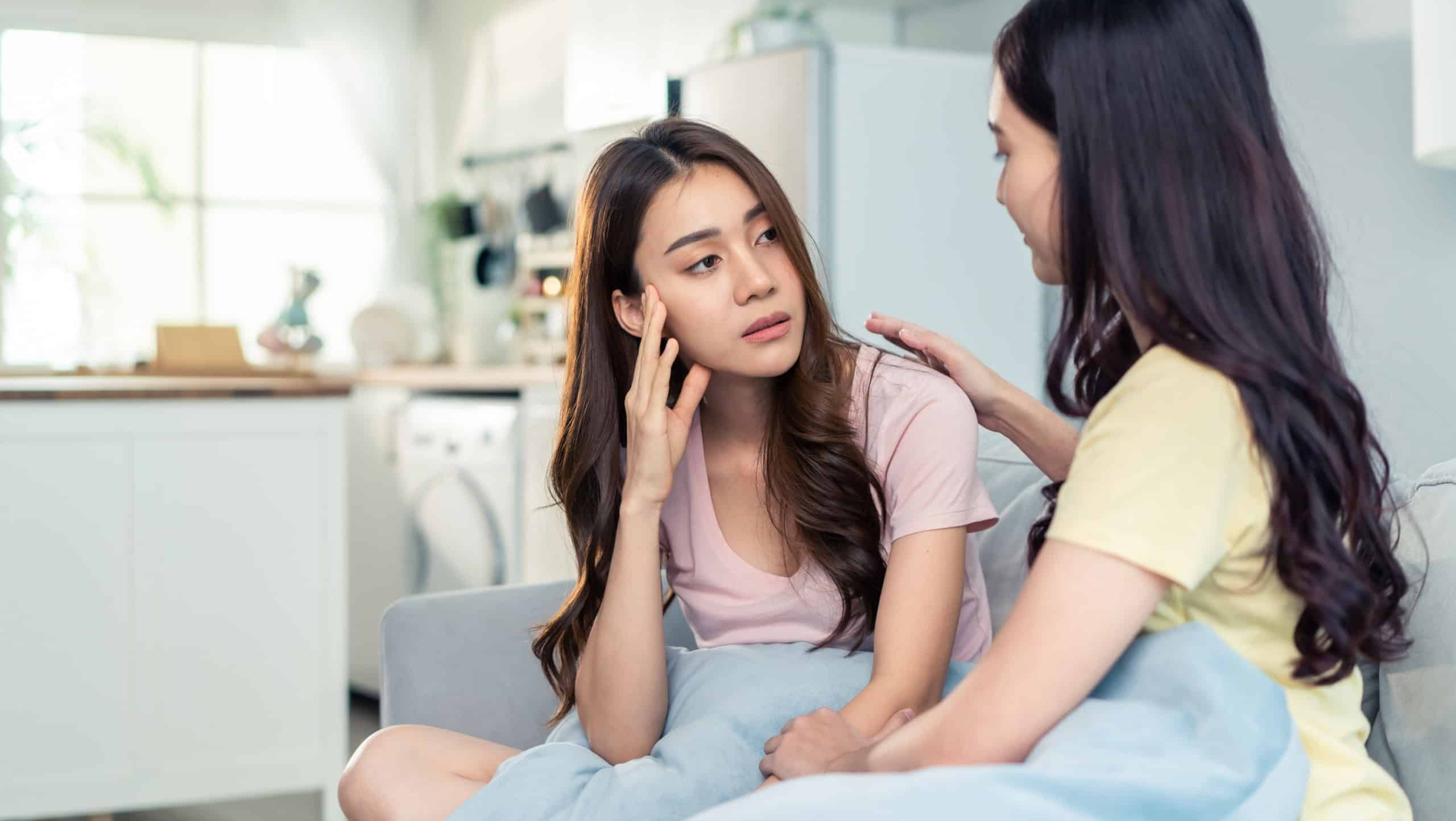 Asian beautiful woman comforts upset girl friend crying for problem. Attractive carring female support, consoling and understand empathy to stressed young sister in tears at home. Family relationship.