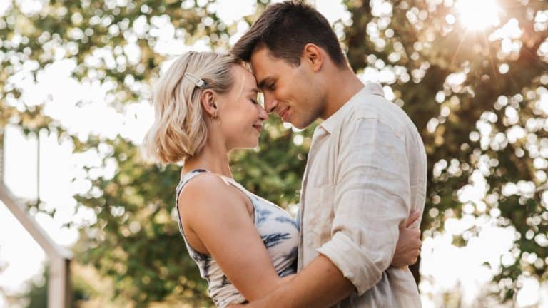 summer holidays, love and people concept - happy young couple hugging outdoors