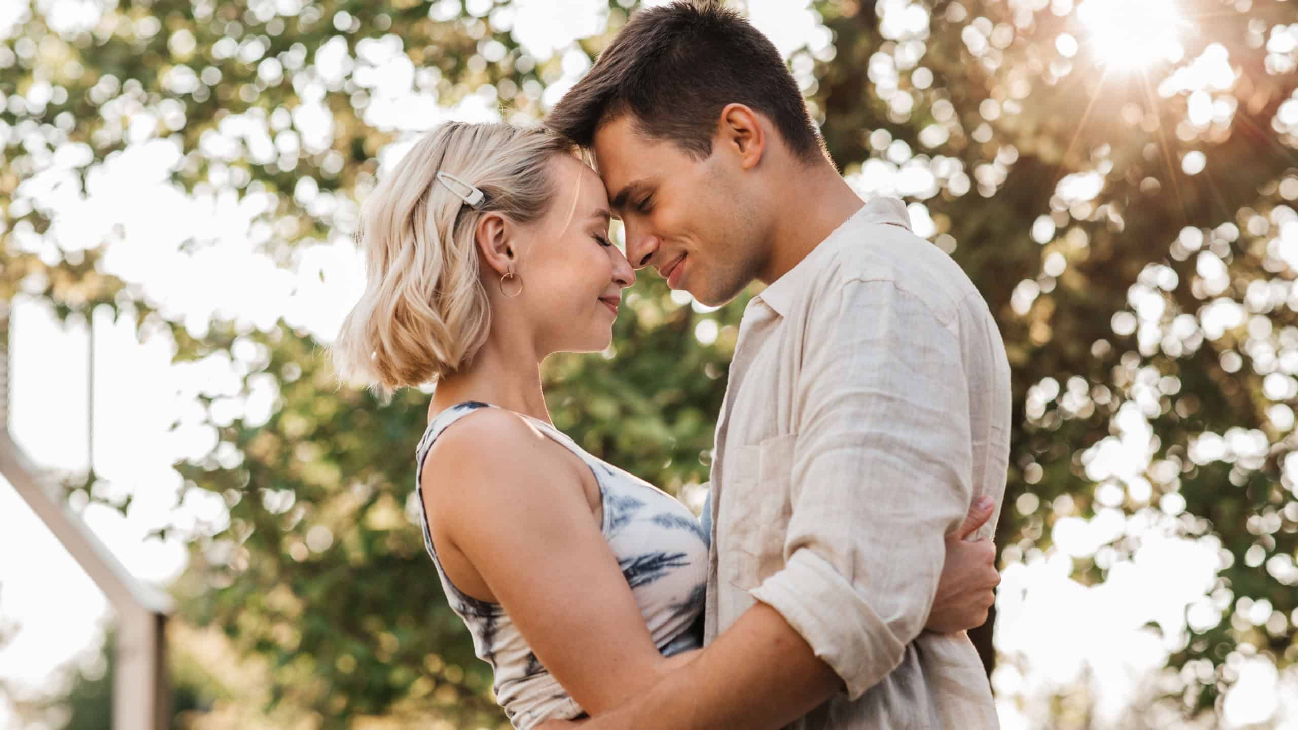 summer holidays, love and people concept - happy young couple hugging outdoors