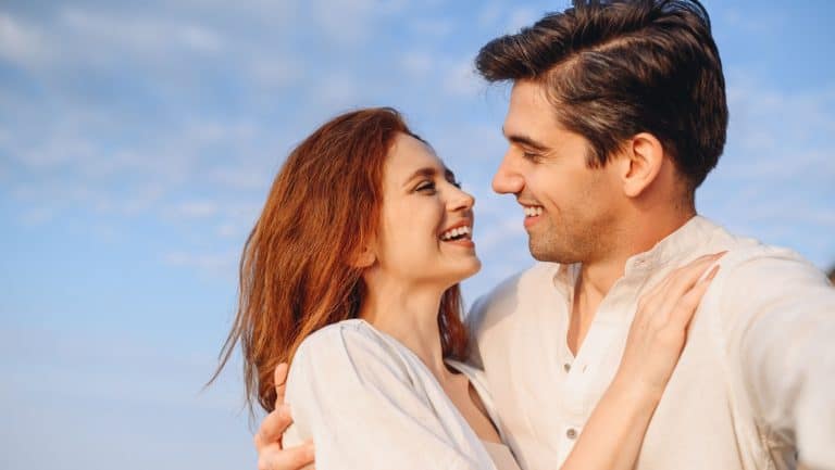 Close up enamored young couple two family man woman in white clothes hug look to each other do selfie shot pov on mobile phone at sunrise over sea beach outdoor seaside in summer day sunset evening