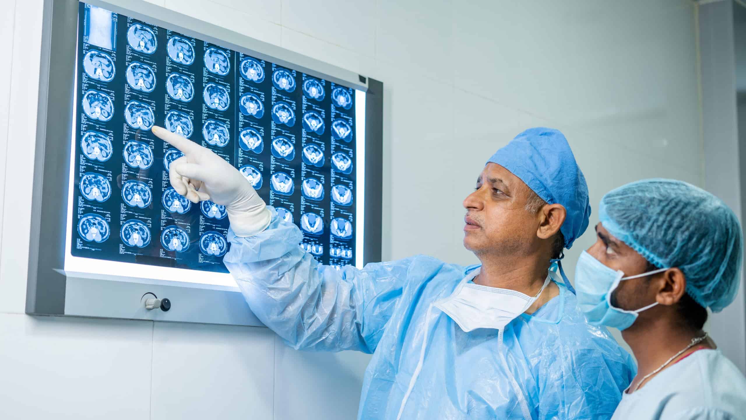 Doctors in operating gowns analyzing X-ray