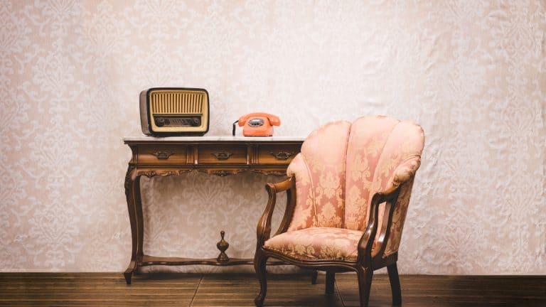 Old telephone, radio and armchair in an interior place with retro style decoration.