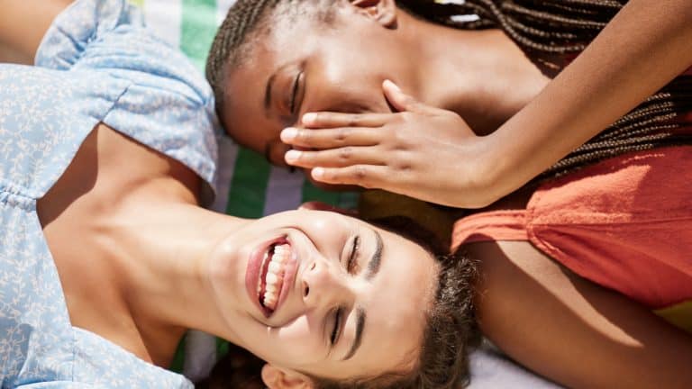 Whisper, secret and gossip with woman friends sharing stories with her girl friend outdoor from above. Laughing, quiet and funny with a young female and girlfriend sharing a joke together outside