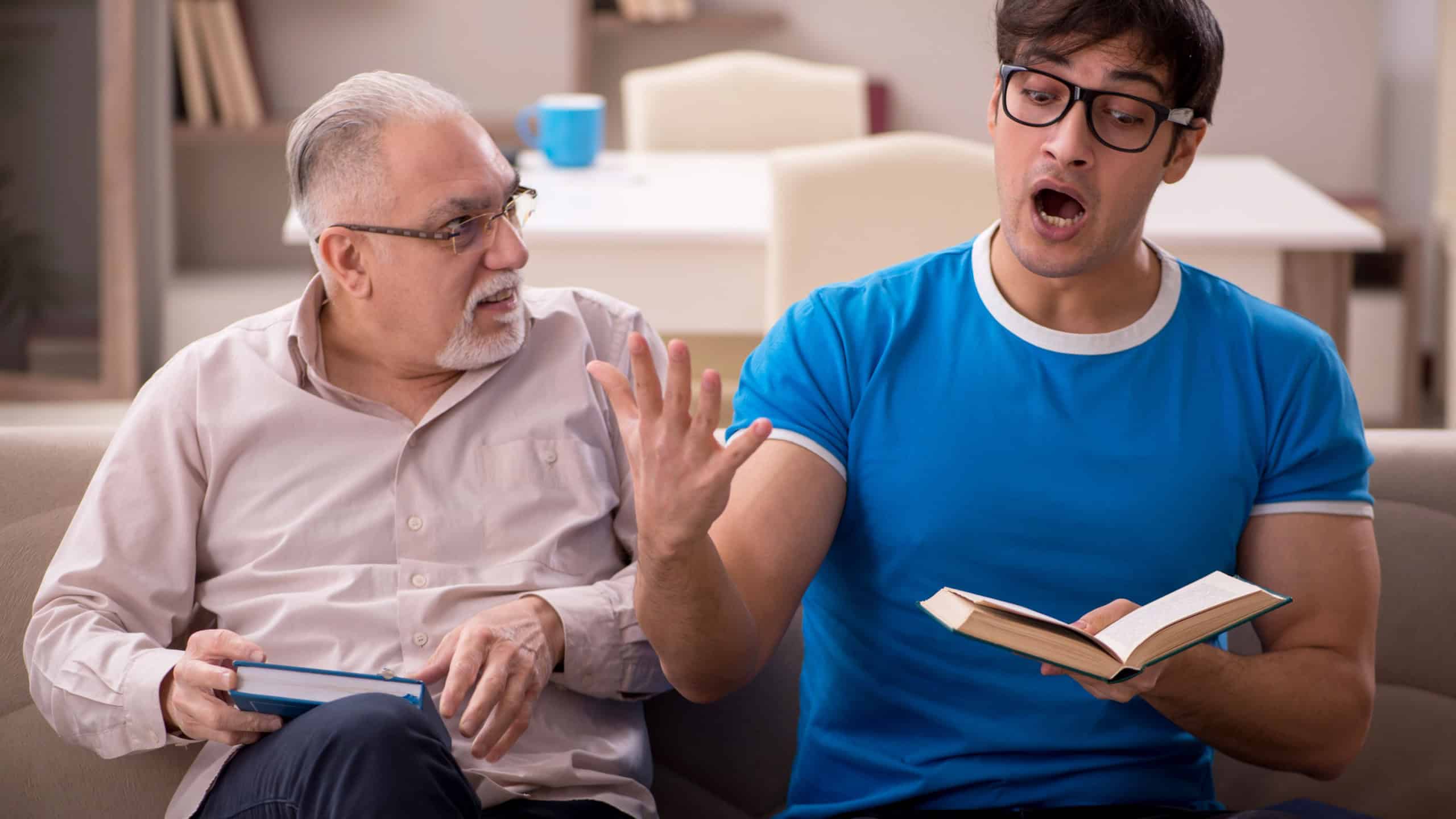 Young male student and his grandfather at home arguing