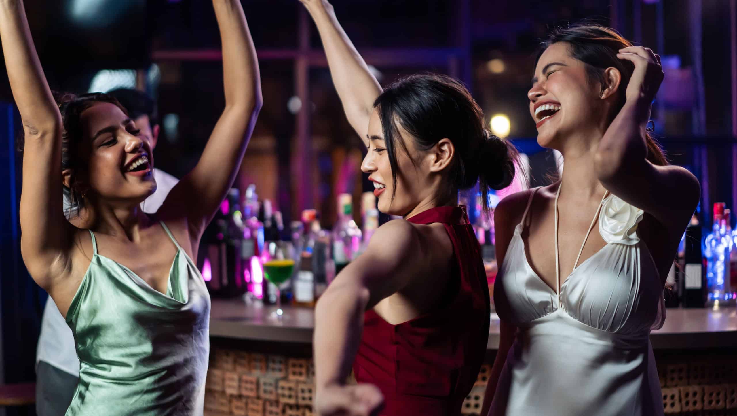 Asian beautiful women having fun, meeting each other in bar restaurant. Attractive young girll friends feeling happy and relax having a party, drinking an alcohol to celebrating event at night club.