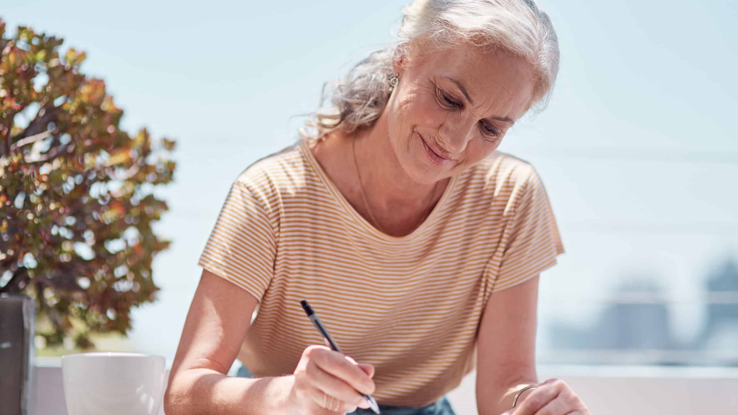 Writing, book and a senior woman author sitting outdoor in summer for inspiration as a writer. Idea, planning and notebook with a female journalist using a pen to write in a journal or diary outside