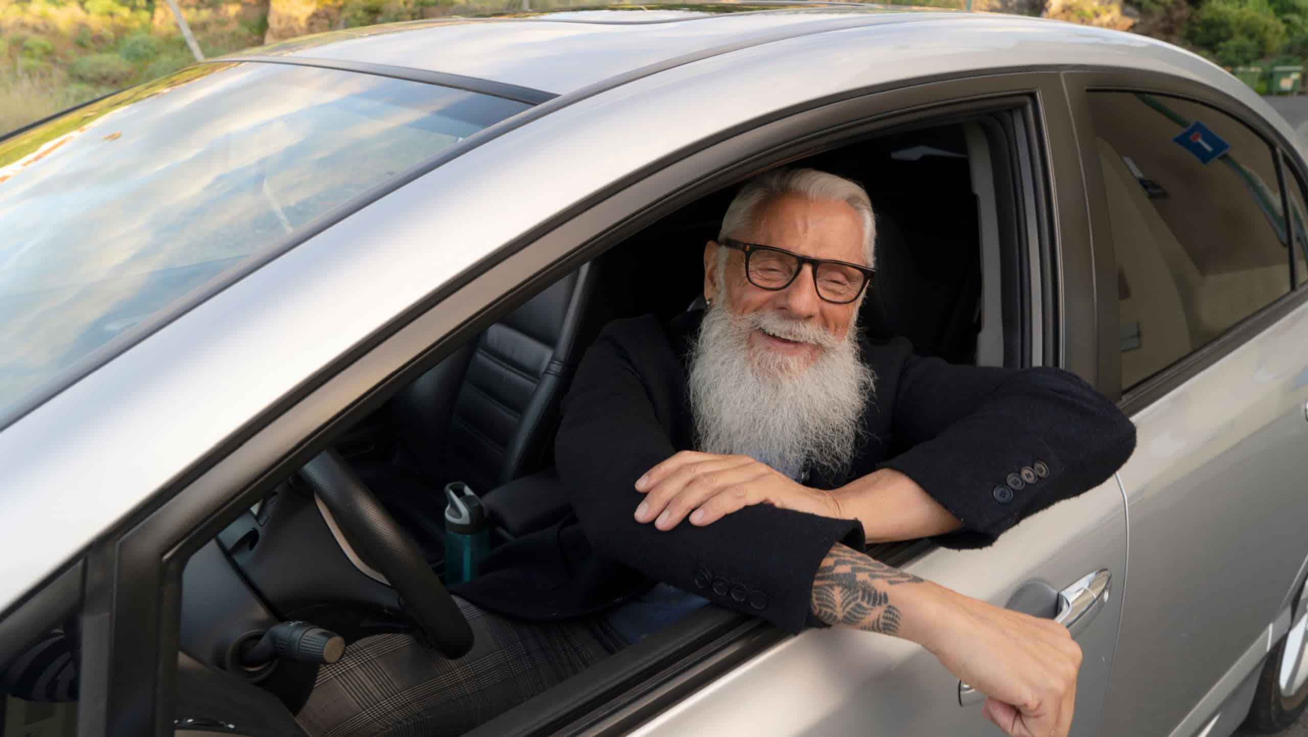 Senior man sitting in car and driving