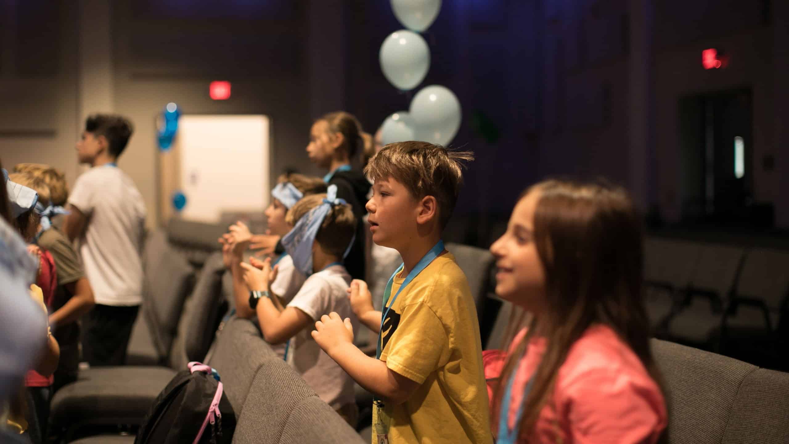 Group of little kids playing games, dancing in circle and having fun at church