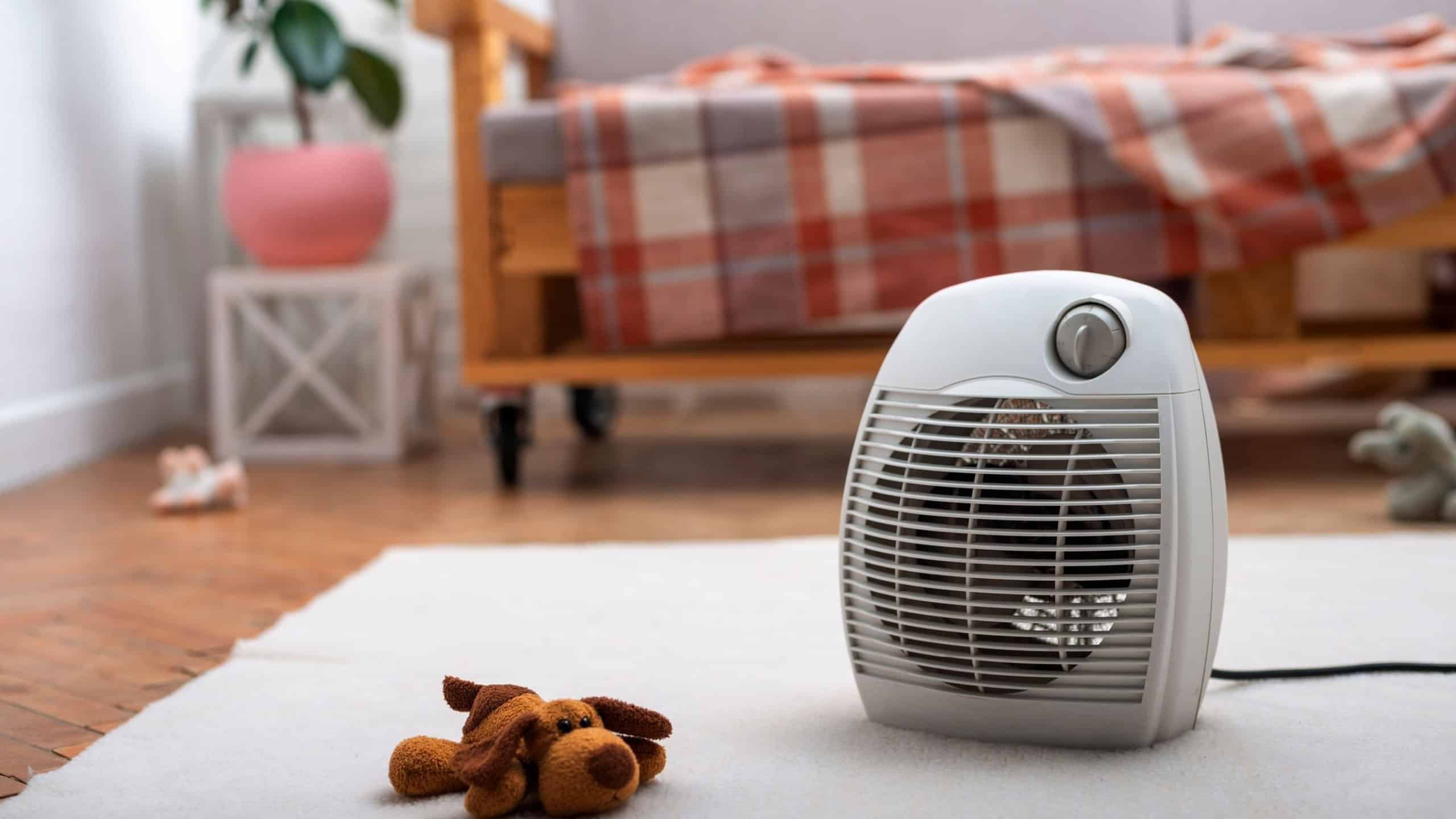 Fan heater on the floor in living room with sofa at background