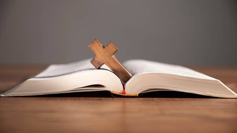 cross on open bible wooden table
