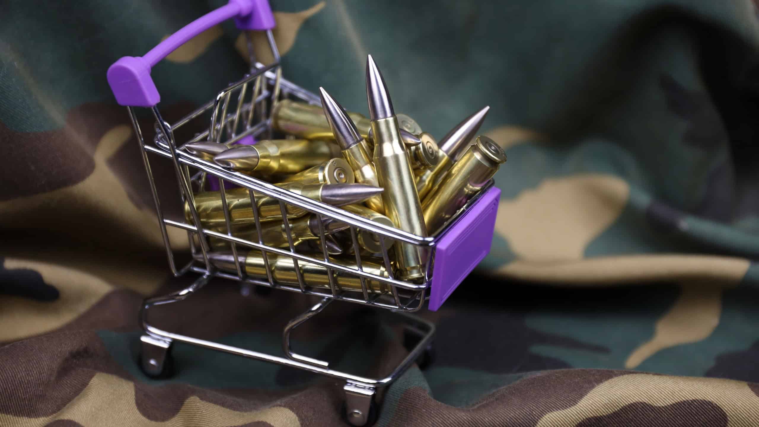 Rifle cartridges in small shopping cart. Big caliber ammo cartridges with a small shopping basket close up
