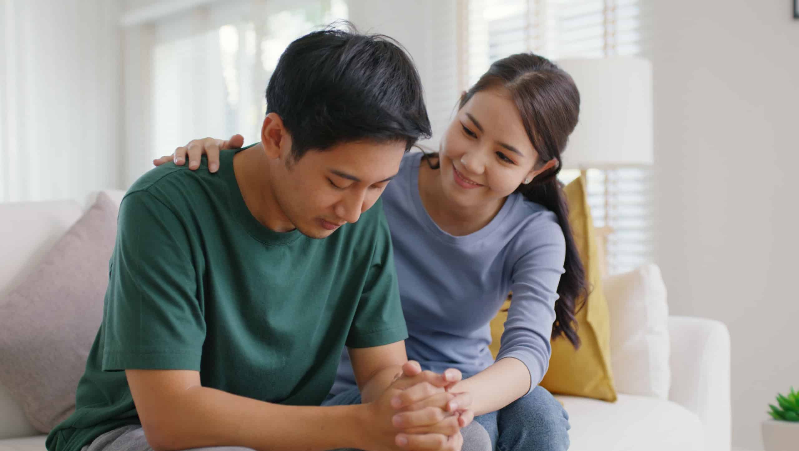 Asia young people stress relief trust talk share suffer cancer pain sick family loss bad news crisis. Sorrow cry man and carer woman sit at sofa home help listen by love hold hand warm hug touch wife.